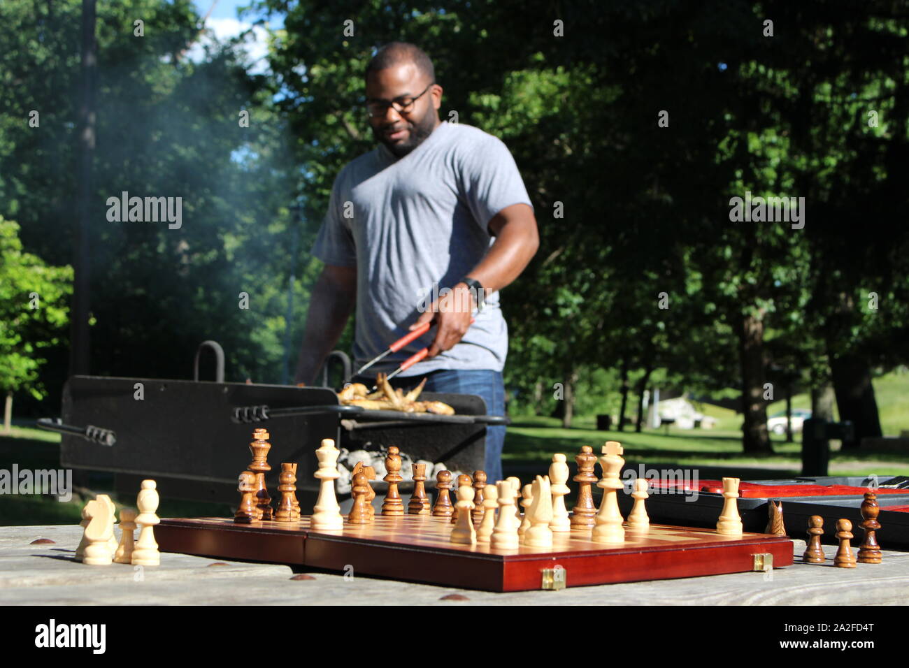 Grilling Outside and Playing a Game of Chess Stock Photo - Alamy