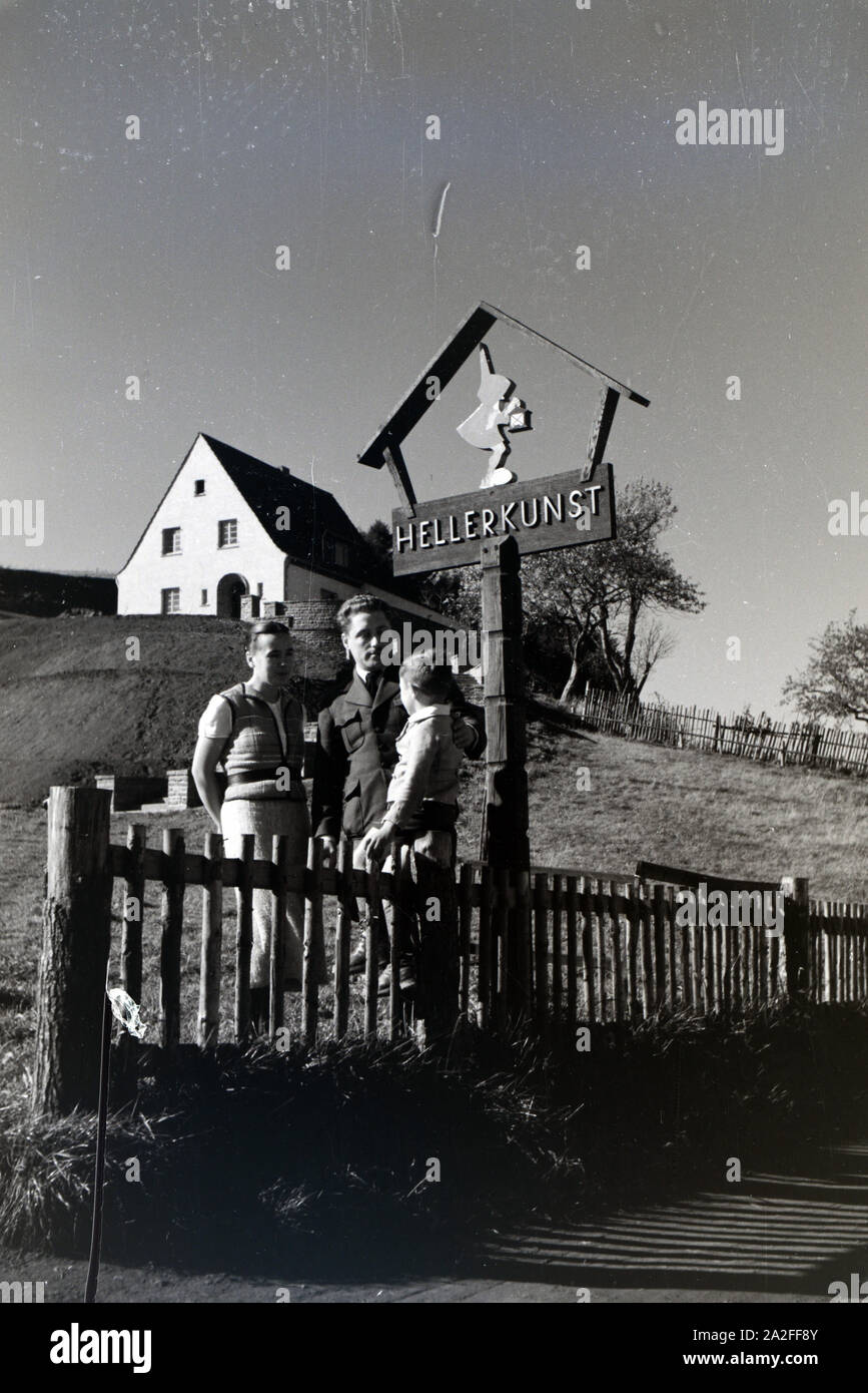 Magda und Georg Heller, die Begründer der Firma Heller Kunst in der Eifel, posieren mit ihrem Sohn vor dem Firmenschild, Deutschland 1930er Jahre. Magda and Georg Heller, the founders of the company Heller Kunst in the Eifel, and their son posing in front of the company signplate, Germany 1930s. Stock Photo