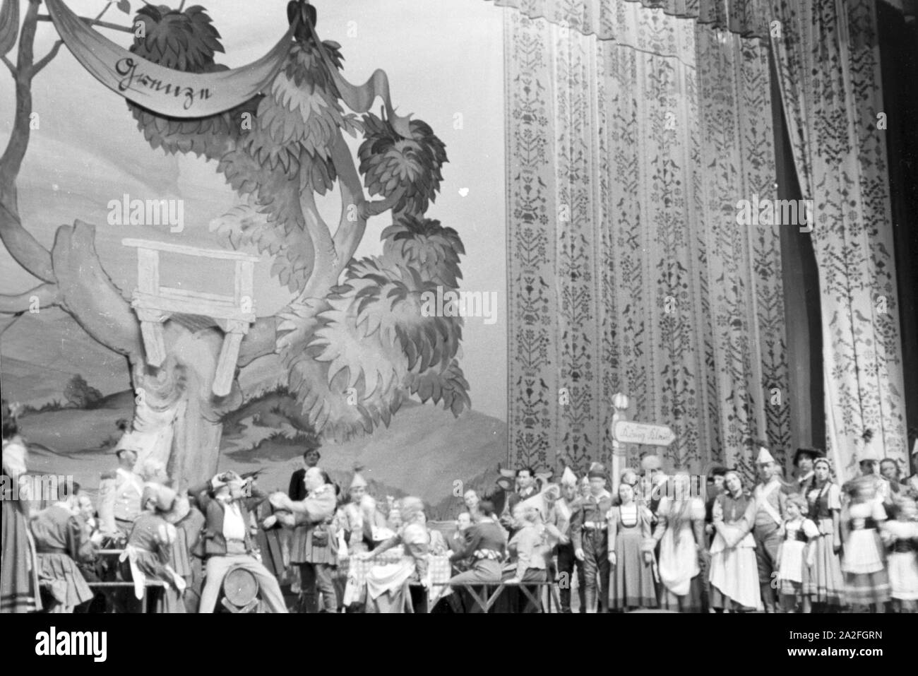 Das aufwendig gestaltete Bühnenbild und die zahlreichen Schauspieler während eines Theaterstücks für Kinder, Deutschland 1930er Jahre. The lavishly designed stage set and the numerous actors during a children´s theatre play, Germany 1930s. Stock Photo