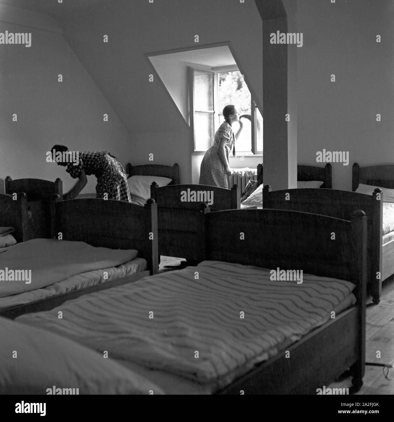 BdM Mädchen beim Bettenmachen im Schlafsaal in der Haushaltungsschule Greifenberg, Deutschland 1930er Jahre. BdM girls making up the beds at the dormitory at the domestic science school at Greifenberg, Germany 1930s. Stock Photo