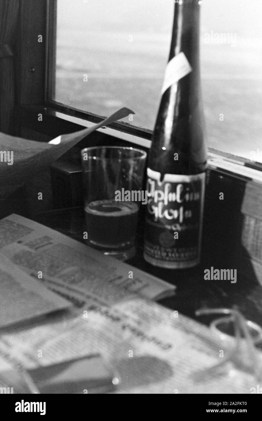 Eine Flasche 'Apfel im Glas' Apfelsaft, Deutschland 1930er Jahre. A bottle and a glass of apple juice, Germany 1930s. Stock Photo