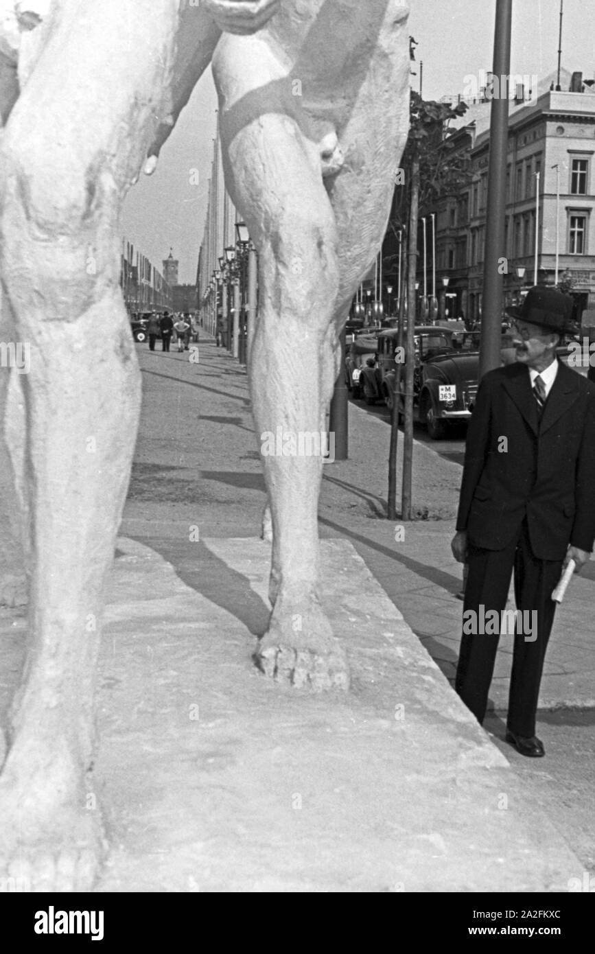 Ein Mann geht in den Straßen Berlins an einem der großen Denkmäler entlang, Deutschland 1930er Jahre. A man walkin alongside of one of the big monuments in the streets of Berlin, Germany 1930s. Stock Photo