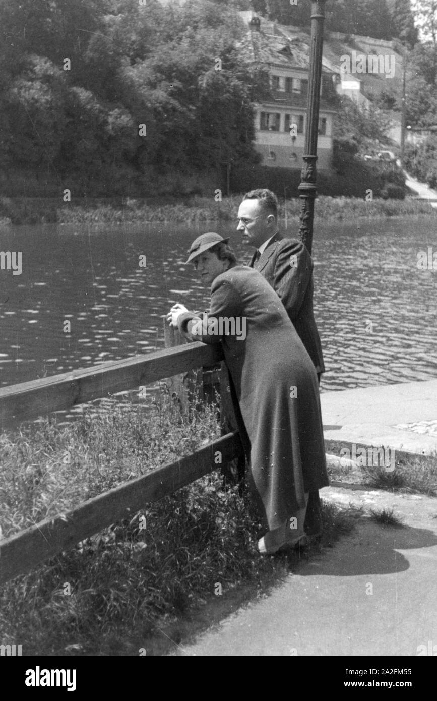Mann und Frau stehen am Ufer eines Flusses, Deutschland 1930er Jahre. Man and woman standing on the shore of a river in Germany, 1930s. Stock Photo