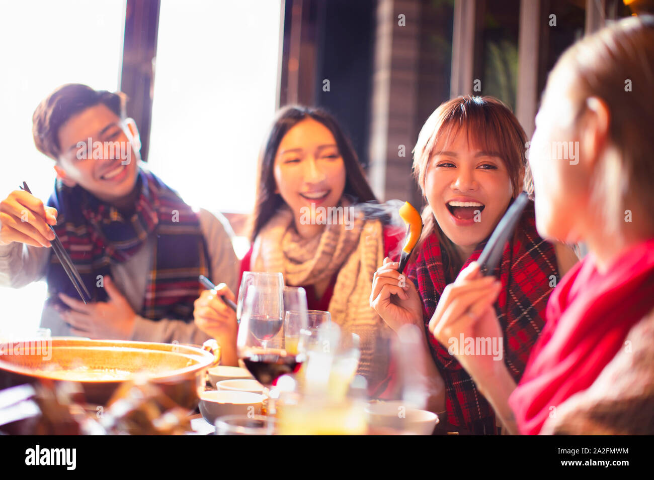 happy young friends eating hot pot in restaurant at winter Stock Photo