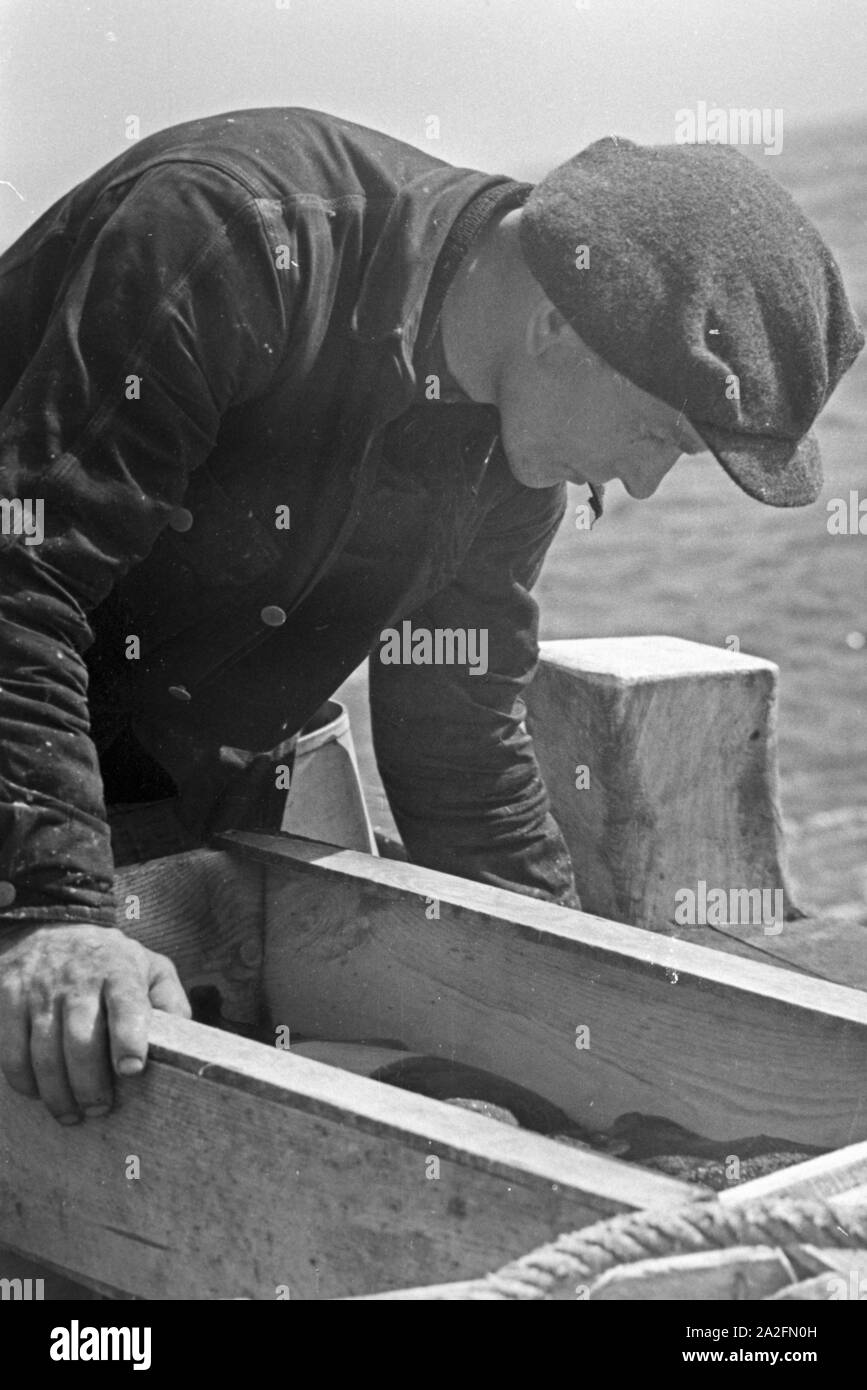 Ein Hochseefischer bei der Arbeit an Deck, Deutschland 1930er Jahre. A deep sea fisherman working on deck, Germany 1930s. Stock Photo