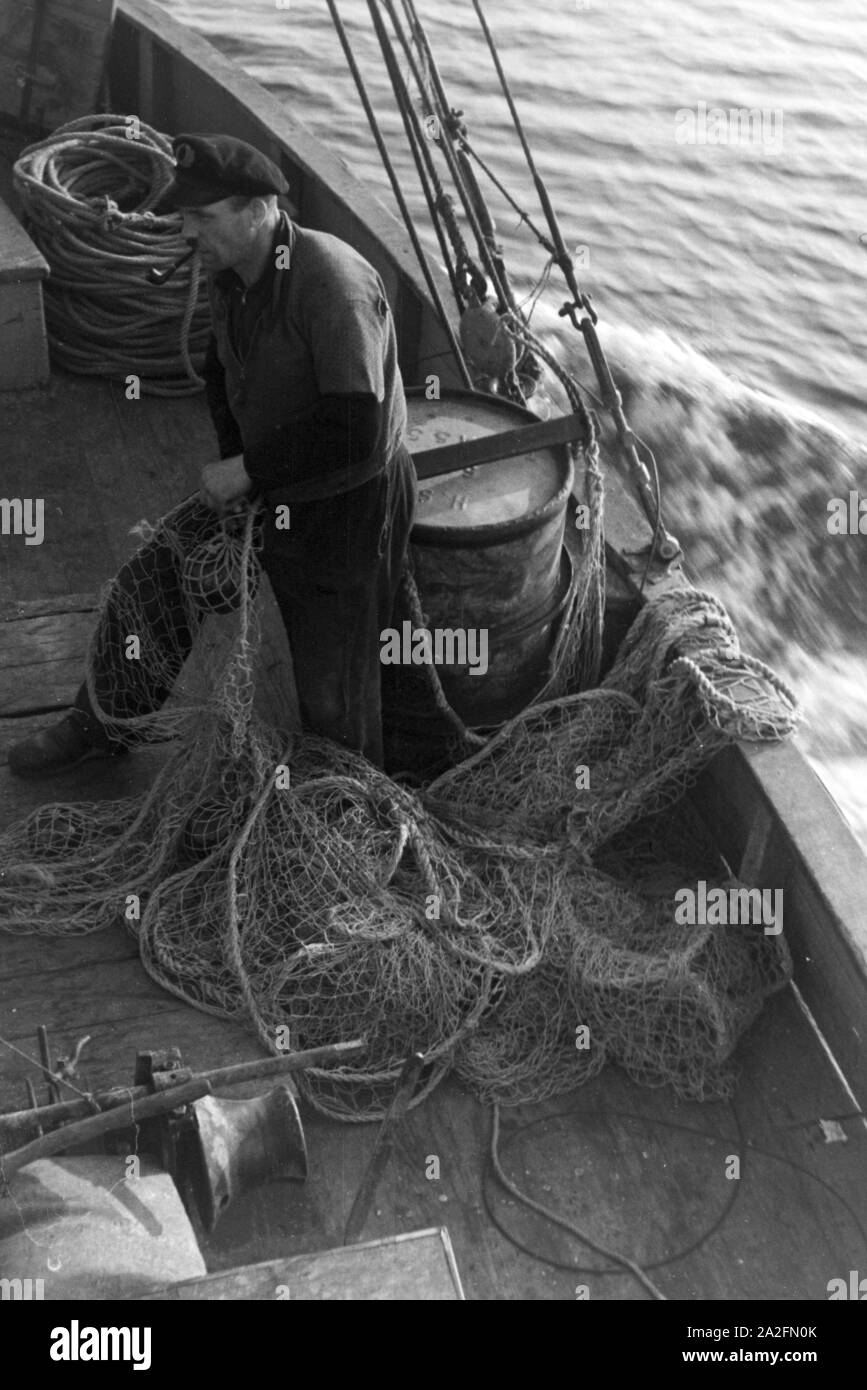 Hochseefischer bereitet die Netze vor, Deutschland 1930er Jahre. Deep sea fisherman preparing the net, Germany 1930s. Stock Photo