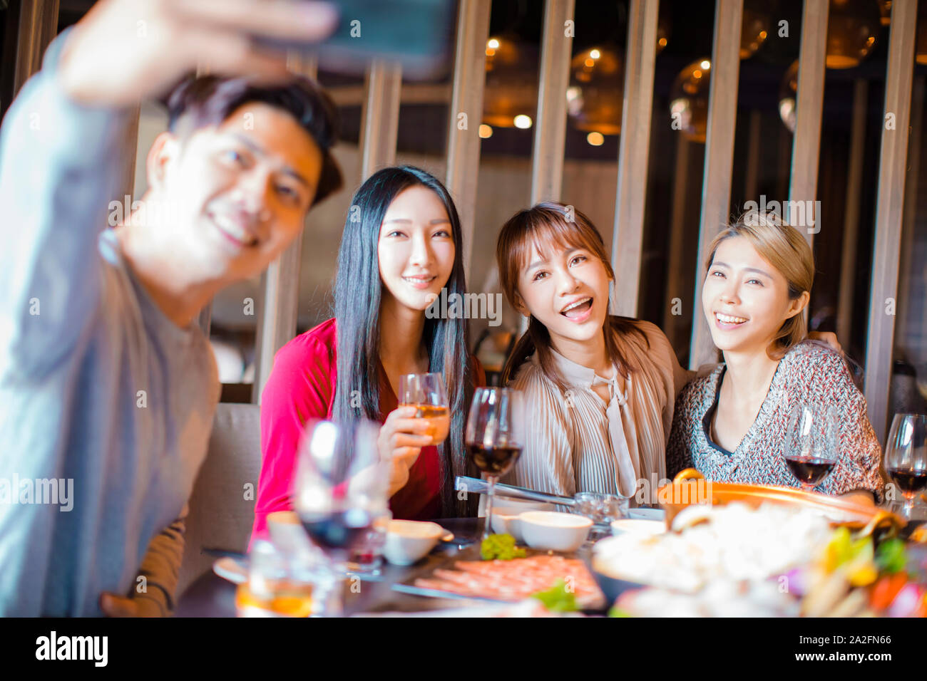Happy friends taking selfie in hot pot restaurant Stock Photo
