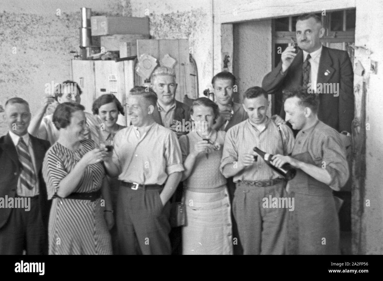 Ein Schlückchen nach getaner Arbeit der Erdbeerernte in Bühl, Deutschland 1930er Jahre. After the strawberry harvest celebrating with a drink at Buehl, Germany 1930s. Stock Photo