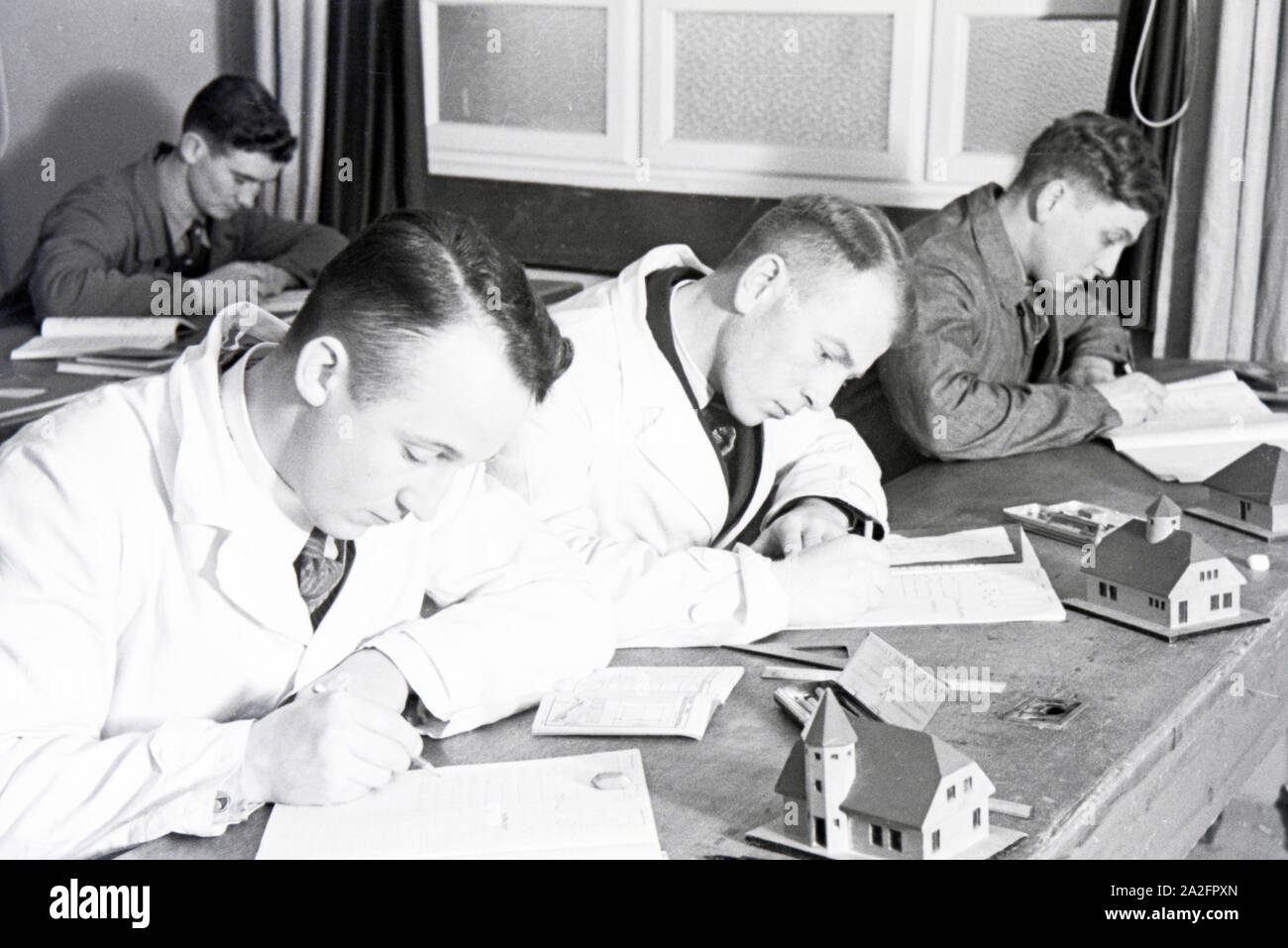 Auszubildende einer Dachdeckerschule bei einer schriftlichen Prüfung, Deutsches Reich 1937. Trainees of a roofer school at a written test, Germany 1937. Stock Photo