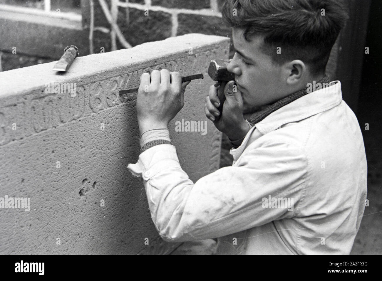 Auszubildender einer Steinmetzschule bei einer Übung, Deutsches Reich 1937. Trainee of a chiseller school at a tutorial, Germany 1937. Stock Photo