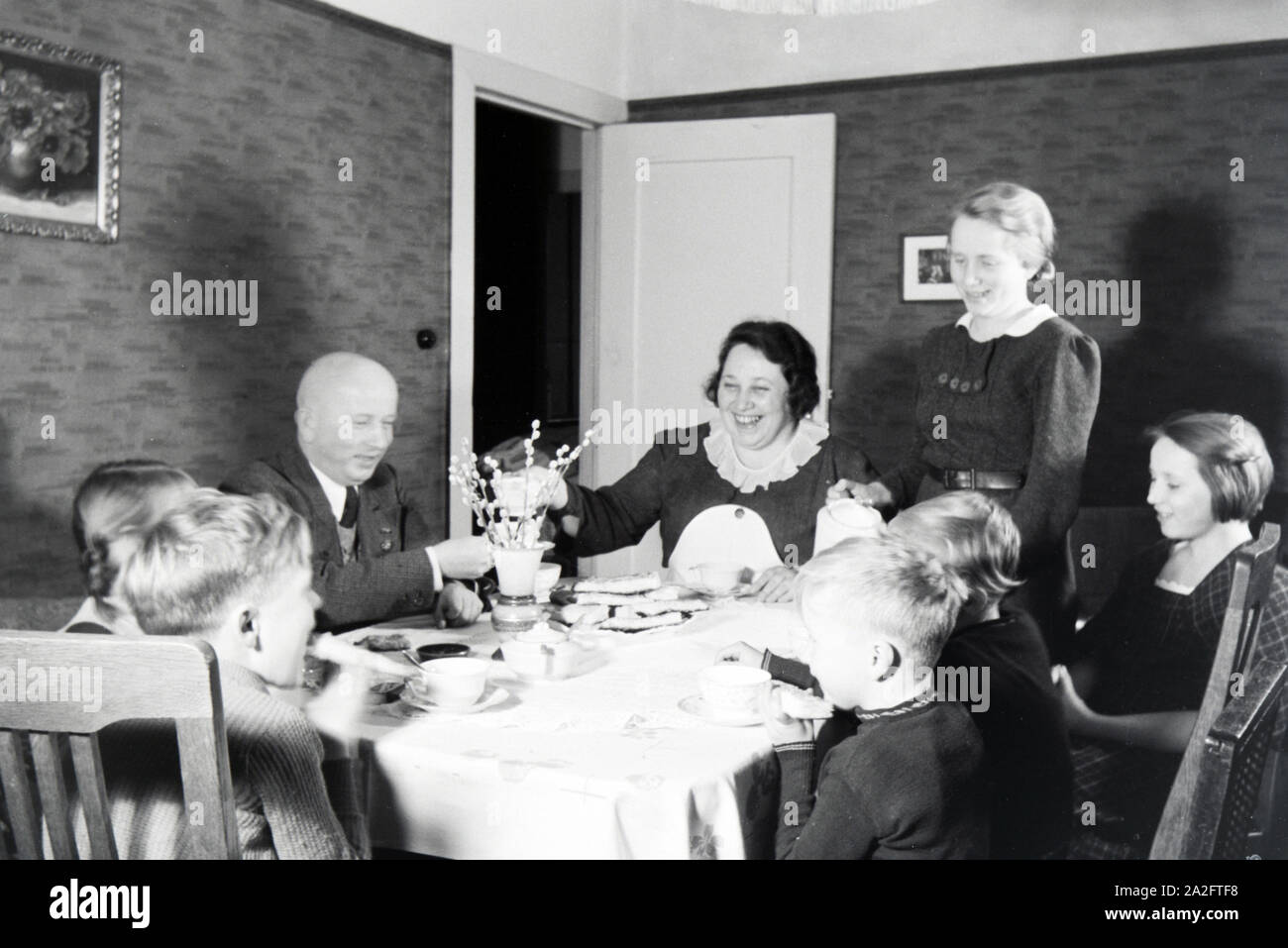 Mitglieder einer kinderreichen Familie bei Kaffe und Kuchen, Deutsches Reich 1930er Jahre. Members of an extended family having coffee and cake, Germa Stock Photo