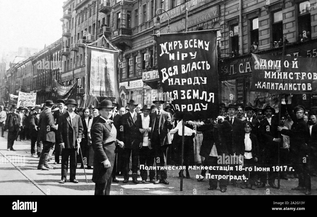 Political demonstration on the Nevsky Prospect at Petrograd, 18th June 1917. Russian Revolution. Private Collection. Bolshevik slogans are seen on banners. The left banner  “All Power to the People , Peace to the Whole World, All Land to the People” and the right banner  “Down with the minister-capitalists”. Stock Photo