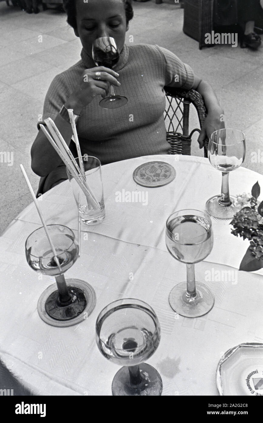 Eine junge Frau probiert ein Getränk im Restaurant des Kurhauscasinos in Baden-Baden, Deutschland 1930er Jahre. A young woman tastes a drink in the restaurant of the Kurhaus Casino in Baden-Baden, Germany 1930s. Stock Photo