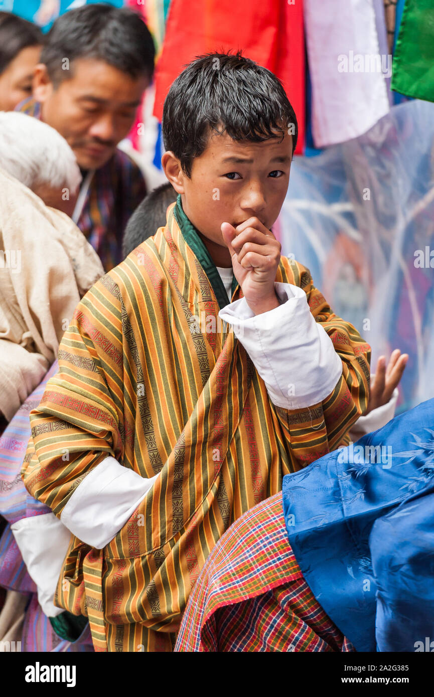 Bumthang, Bhutan, 06 Nov 2011: Bhutanese boy wearing traditional Bhutan robe Gho at a festival. Stock Photo