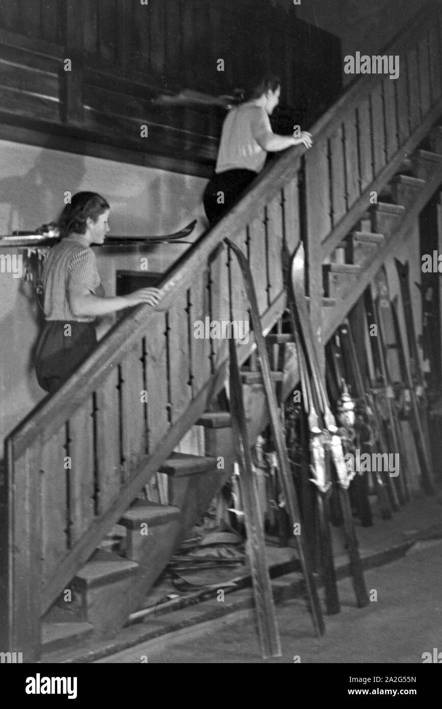 Zwei Anfängerinnen aus einem Trockenskikurs auf einer Treppe einer Skihalle, Deutschland 1930er Jahre. Two young beginners at the stairs of a training skiing hall, Germany 1930s. Stock Photo