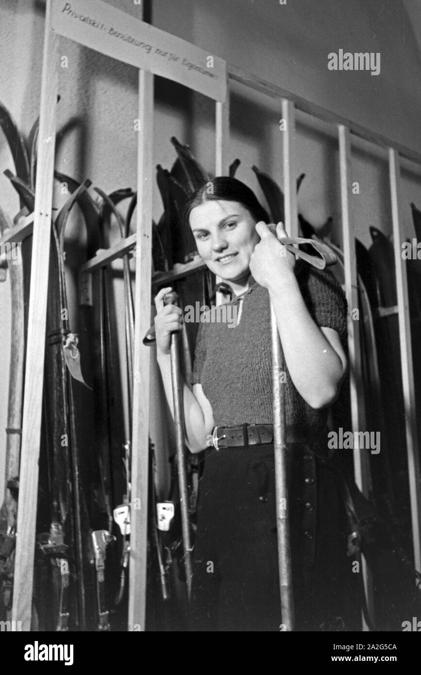 Eine juneg Ski-Anfängerin hat die richtigen Skier für sich gefunden, Deutschland 1930er Jahre. A young female skiing beginner chose the best skiers for her first attempts, Germany 1930s. Stock Photo