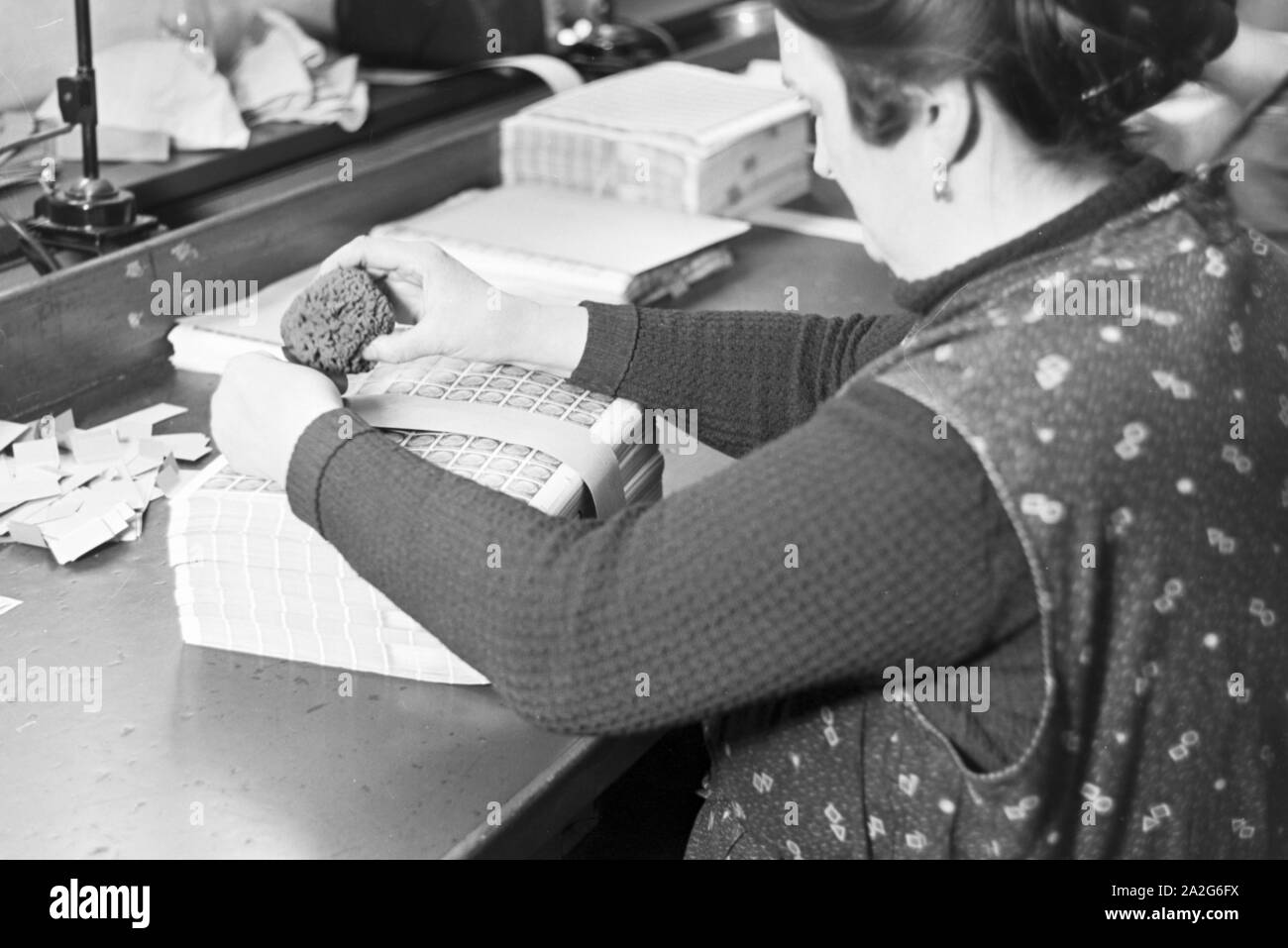 Eine Mitarbeiterin der Reichsdruckerei kommisioniert Hindenburg Dauerserie Briefmarken in Bögen in Berlin, Deutschland 1930er Jahr. A female staff member of the Reichsdruckerei printing plant in Berlin commissioning Hindenburg stamp sheets, Germany 1930s. Stock Photo