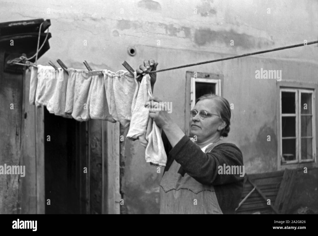 Die Großmutter macht die Wäsche für die Knipser Vierlinge, Deutschland 1930er Jahre. Grandmother is doing the washing of Knipser's quadruplet girls, Germany 1930s. Stock Photo