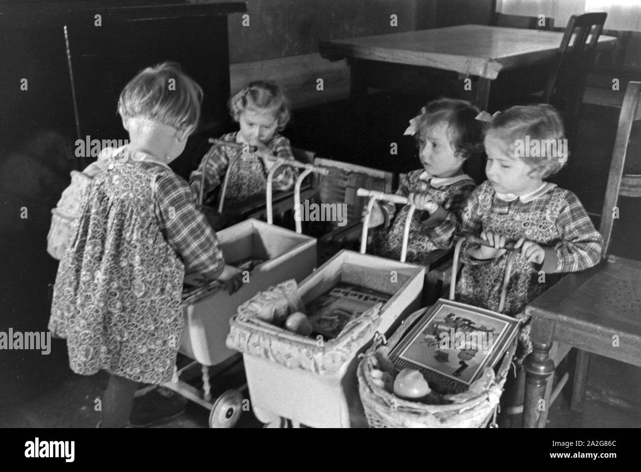 Die Knipser Vierlinge als Kleinkinder mit ihren Puppenwagen, Deutschland 1930er Jahre. Knipser's quadruplet girls with their doll's prams, Germany 1930s. Stock Photo