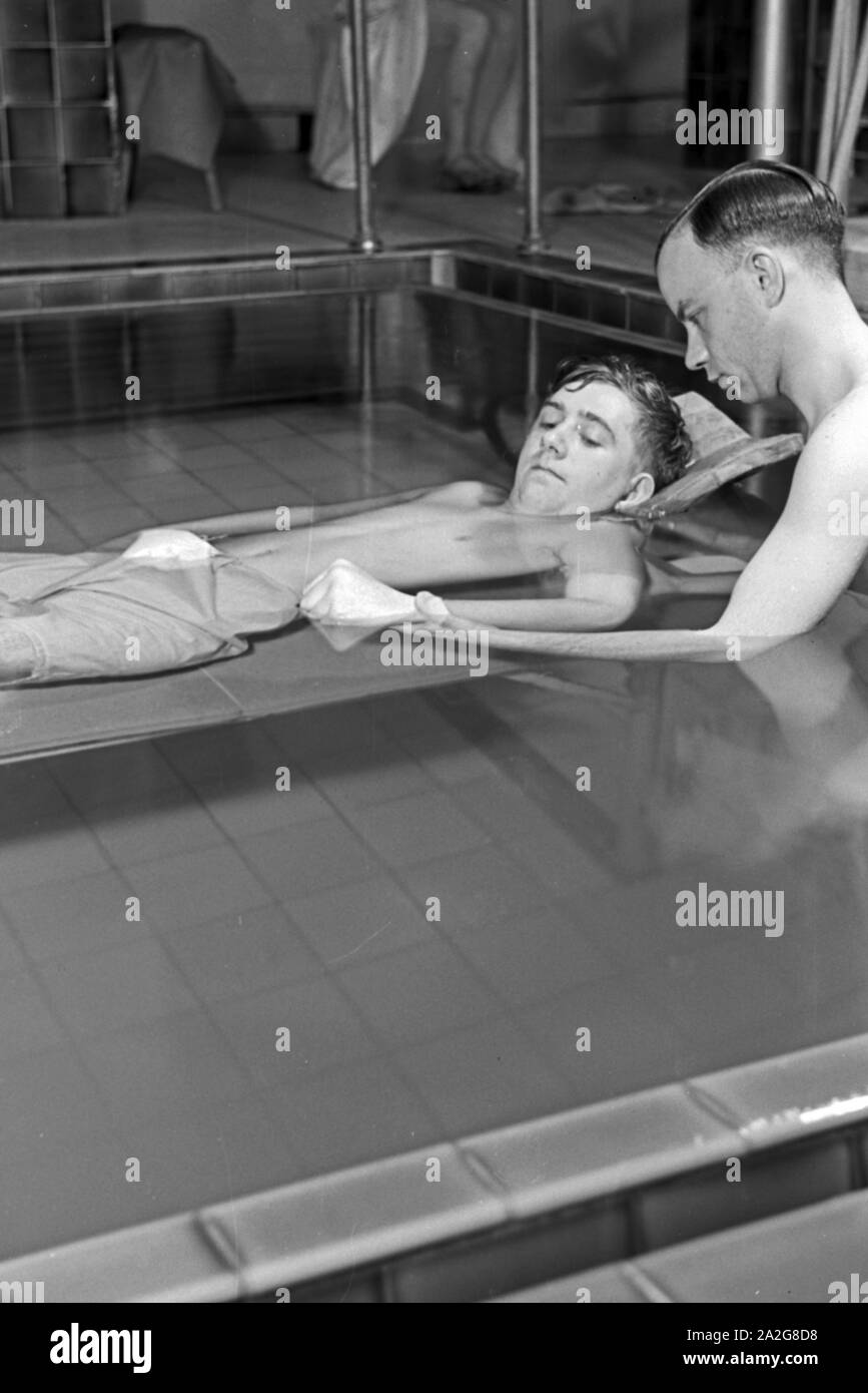 Ein Patient bei der Unterwasserbehandlung mit einem Bademeister, Deutschland 1930er Jahre. A patient in a therapeutic bath, Germany 1930s. Stock Photo