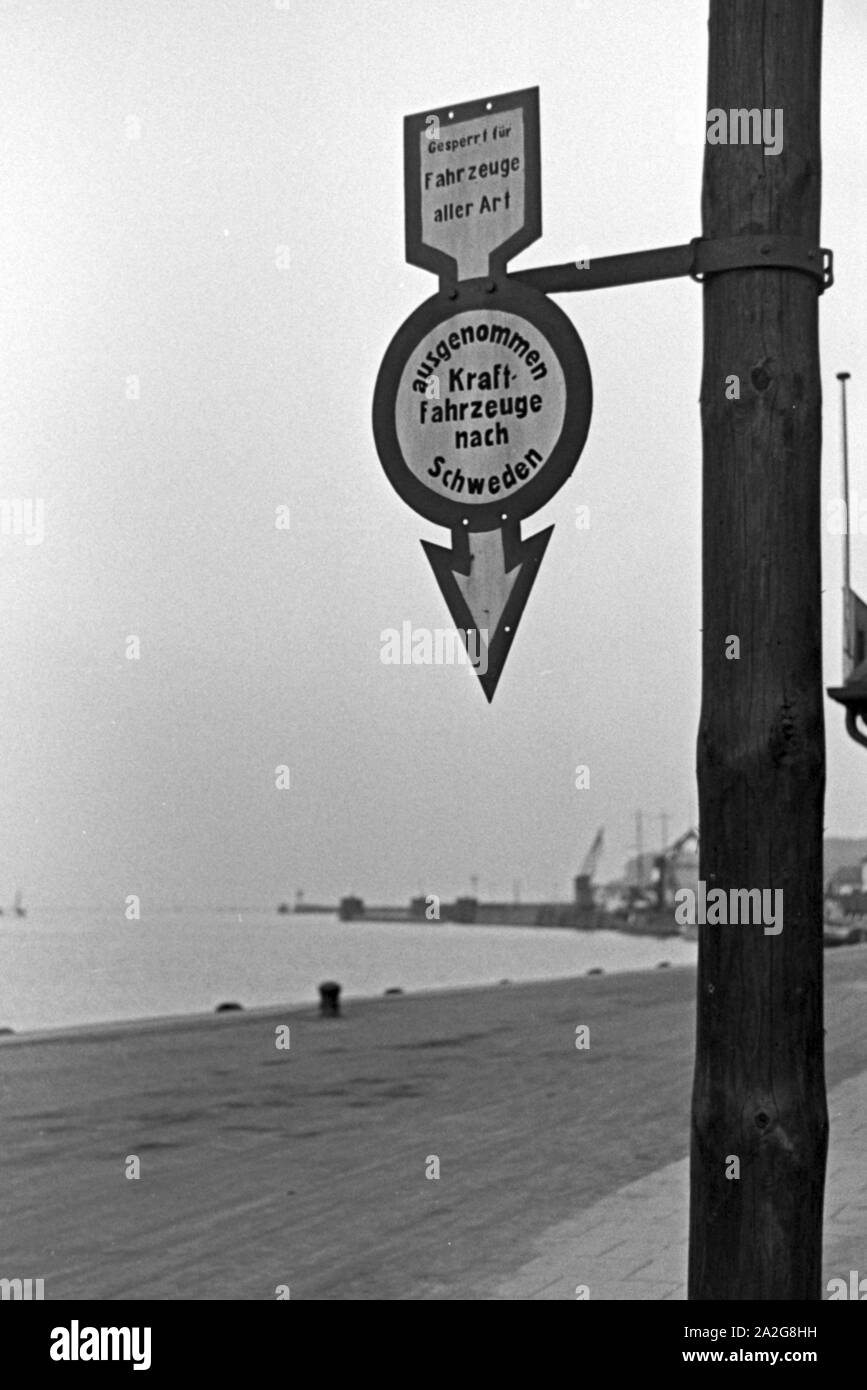 Straßenschild, das die Durchfahrt für Kraftfahrzeuge auf der Mole in Hela verbietet mit Ausnahme Schweden als Reiseziel, Ostpreußen, Deutschland 1930er Jahre. Traffic sign prohibiting driving at the mole in Hela, exception for cars with destination Sweden, East Prussia, Germany 1930s. Stock Photo