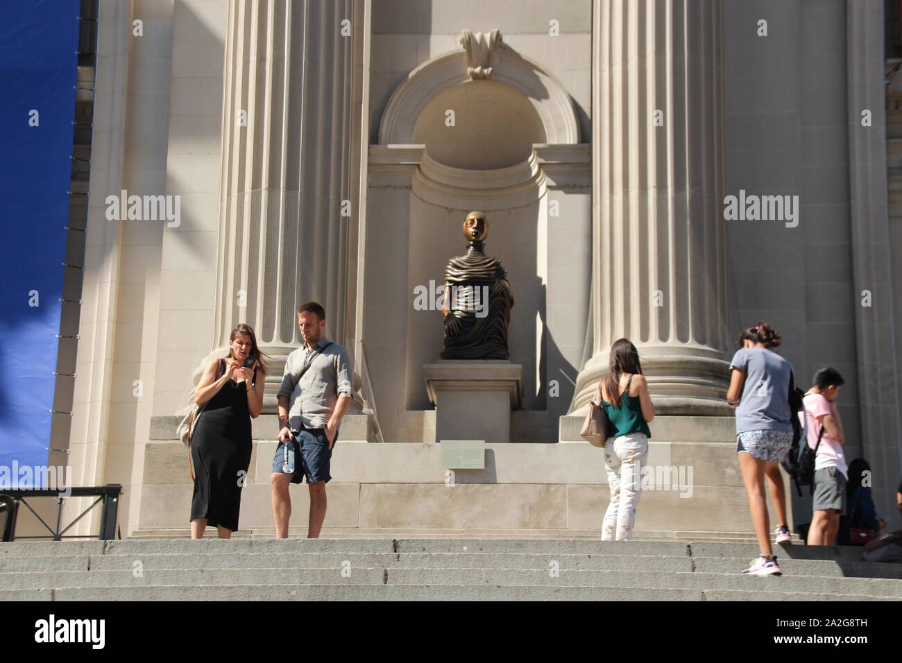 02 October 2019, US, New York: Already during the construction of the facade of the Metropolitan Museum in New York, four niches for sculptures were left open - now they have been filled for the first time in 117 years. Four different bronze sculptures by the Kenyan-American artist Wangechi Mutu, inspired by African women's customs, have recently been on display on the façade. "The Seated I, II, III, and IV" is the first installation of a new action by the renowned museum at Central Park in Manhattan. Each year, another artist is commissioned by the museum to "animate" its façade. The four pre Stock Photo