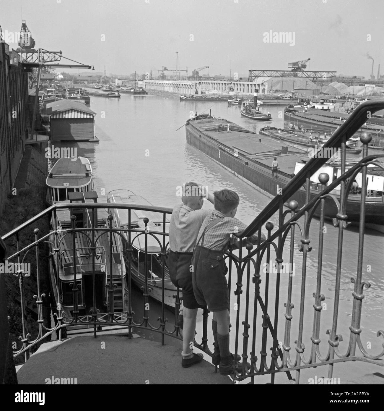 Zwei kleine Jungen schauen von einem Treppengeländer auf den Hafen von Dortmund, Deutschland 1930er Jahre. Two little boys watching Dortmund harbor from a banister rail, Germany 1930s. Stock Photo