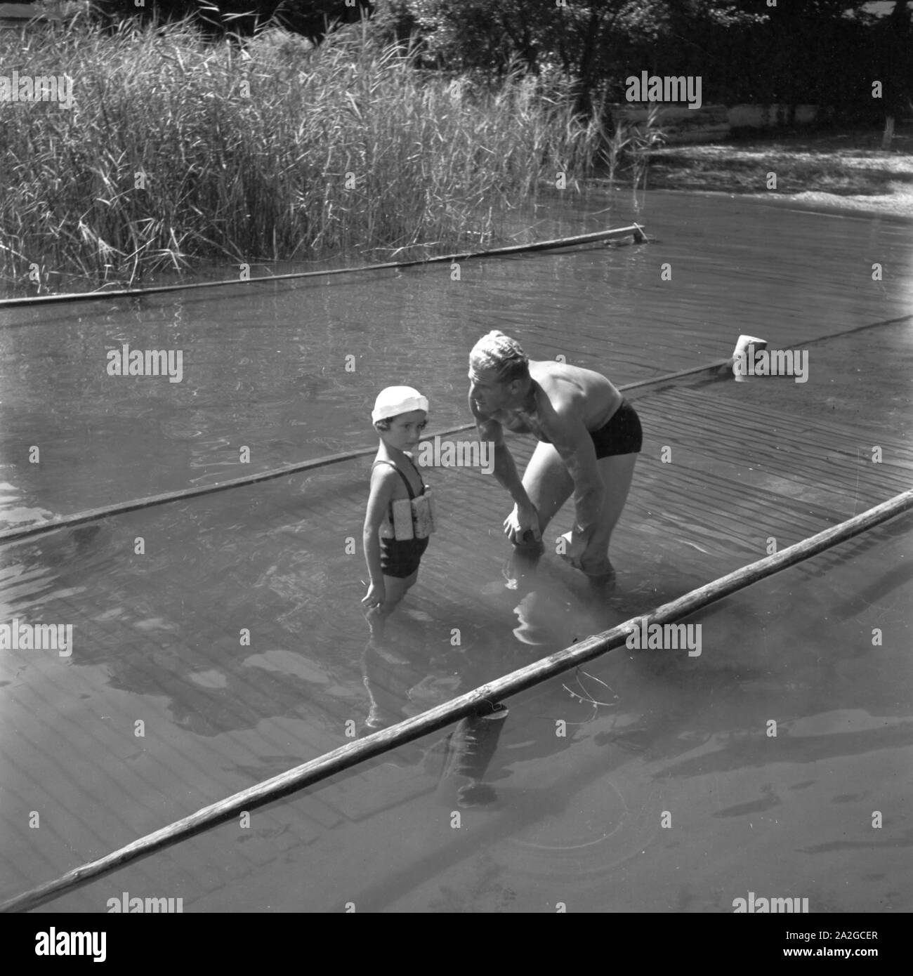 Ein Vater bringt seinem Sohn das Schwimmen bei, Deutschland 1930er Jahre. A father teaches his son how to swim, Germany 1930s. Stock Photo