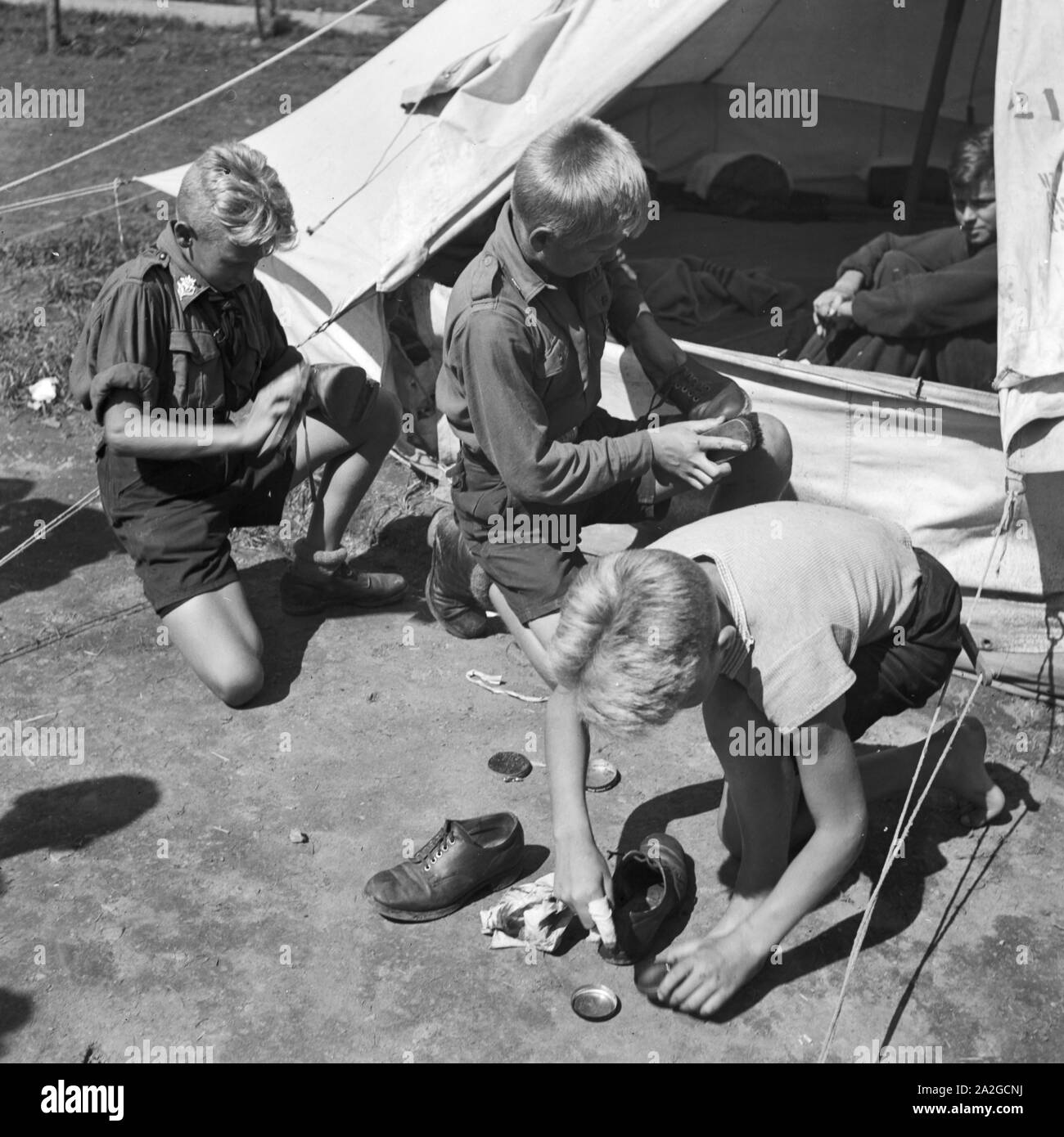 Hitlerjungen beim Schuheputzen im Hitlerjugend Lager, Österreich 1930er Jahre. Hitler youths shining their shoes at the Hitler youth camp, Austria 1930s. Stock Photo