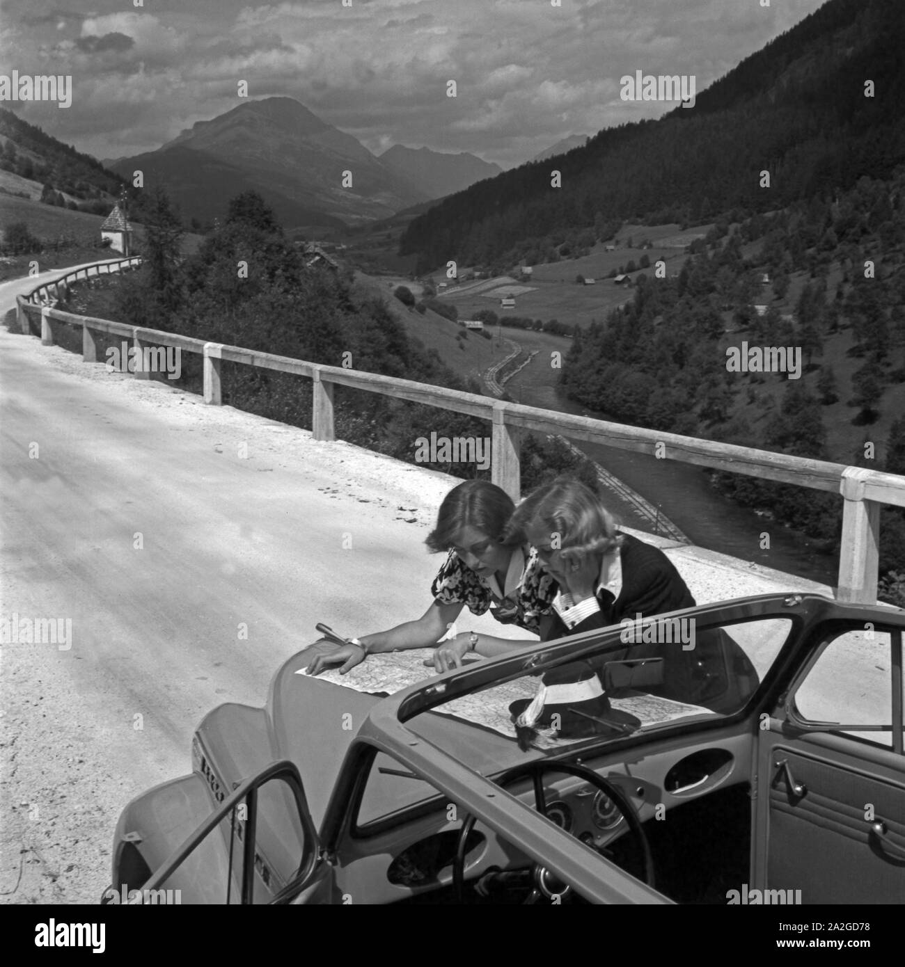 Mit dem Auto unterwegs durch Österreich: zwei Frauen studieren die Karte, 1930er Jahre. Travelling through Austria by car: two women studying the road map, 1930s. Stock Photo