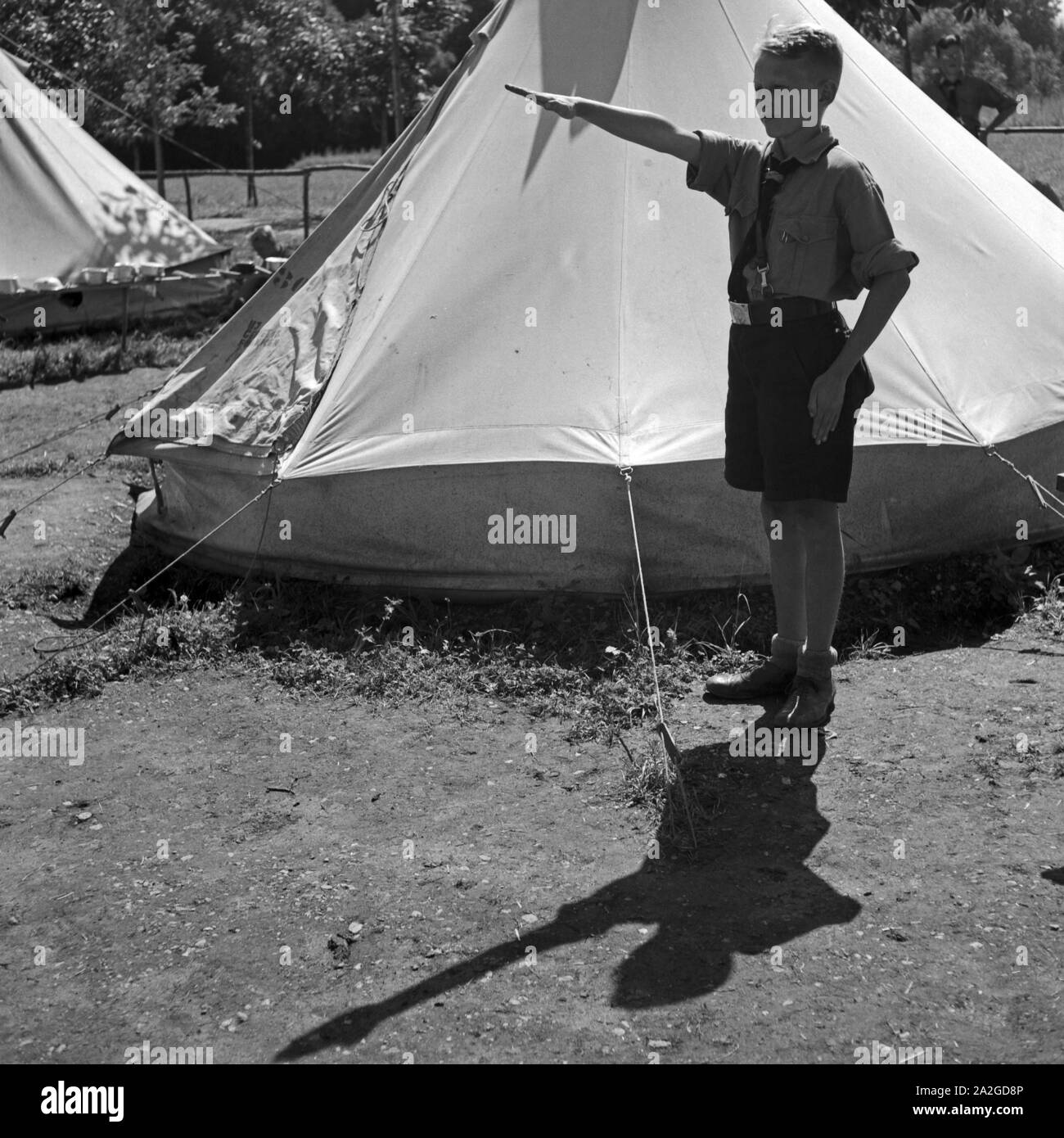 Ein Hitlerjunge beim Grüßen eines Vorgesetzten mit dem Deutschen Gruß im Hitlerjugend Lager, Österreich 1930er Jahre. A Hitler youth saluting a superior wit hthe Nazi salute at the Hitler youth camp, Austria 1930s. Stock Photo