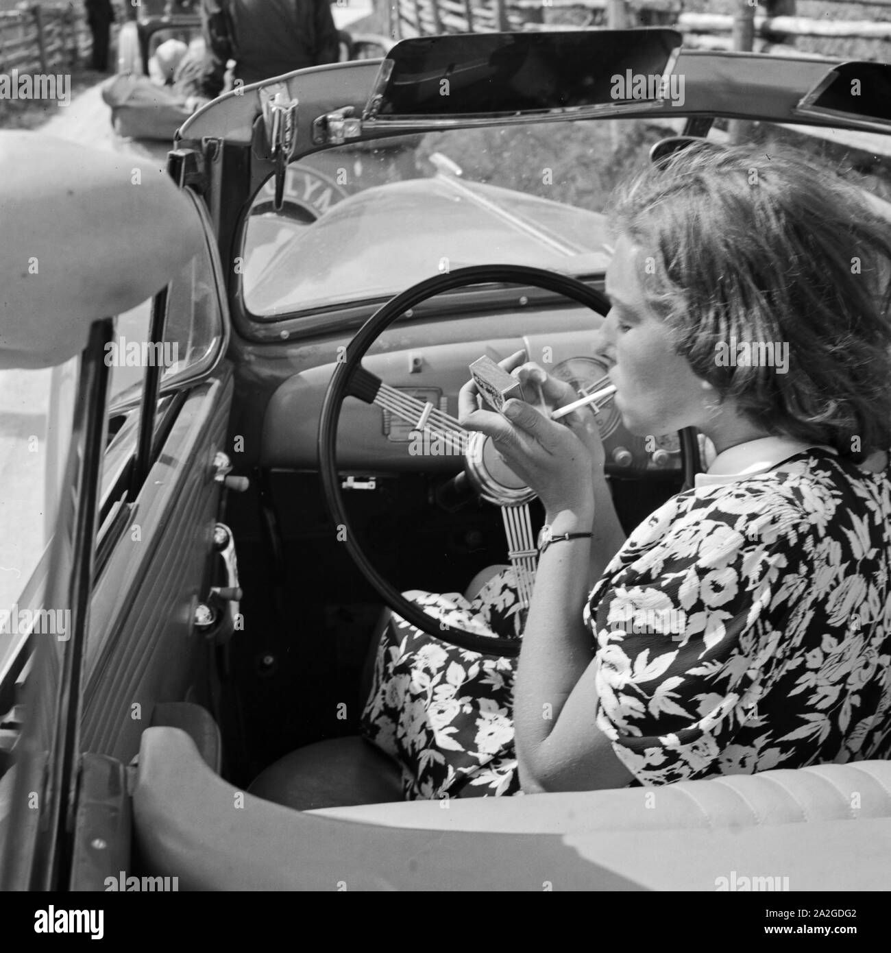 Eine junge Frau raucht am Steuer eines Opel Olympia, Deuitschland 1930er Jahre.  A ypung woman smoking in her Opel model Olympia, Germany 1930s. Stock Photo