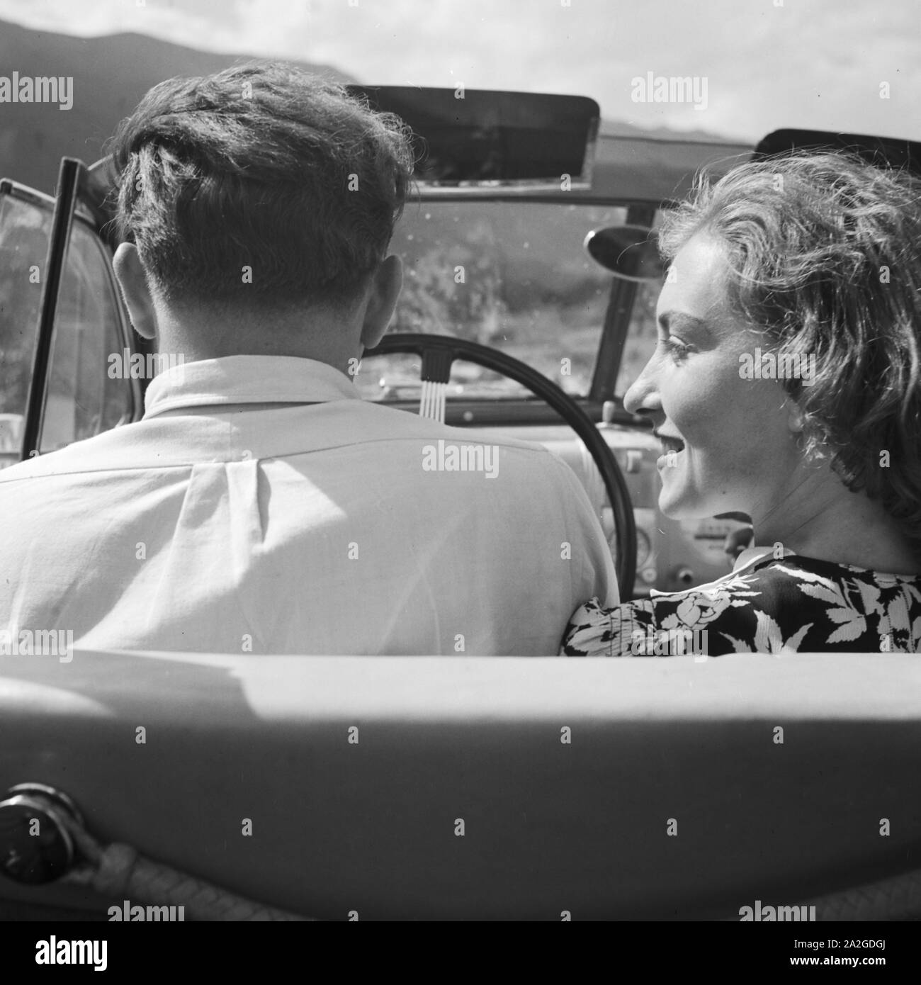 Eine Frau und ein Mann fahren in einem Opel Olympia, Deutschland 1930er Jahre. A woman and a man driving in s Opel model Olympia, Germany 1930s. Stock Photo