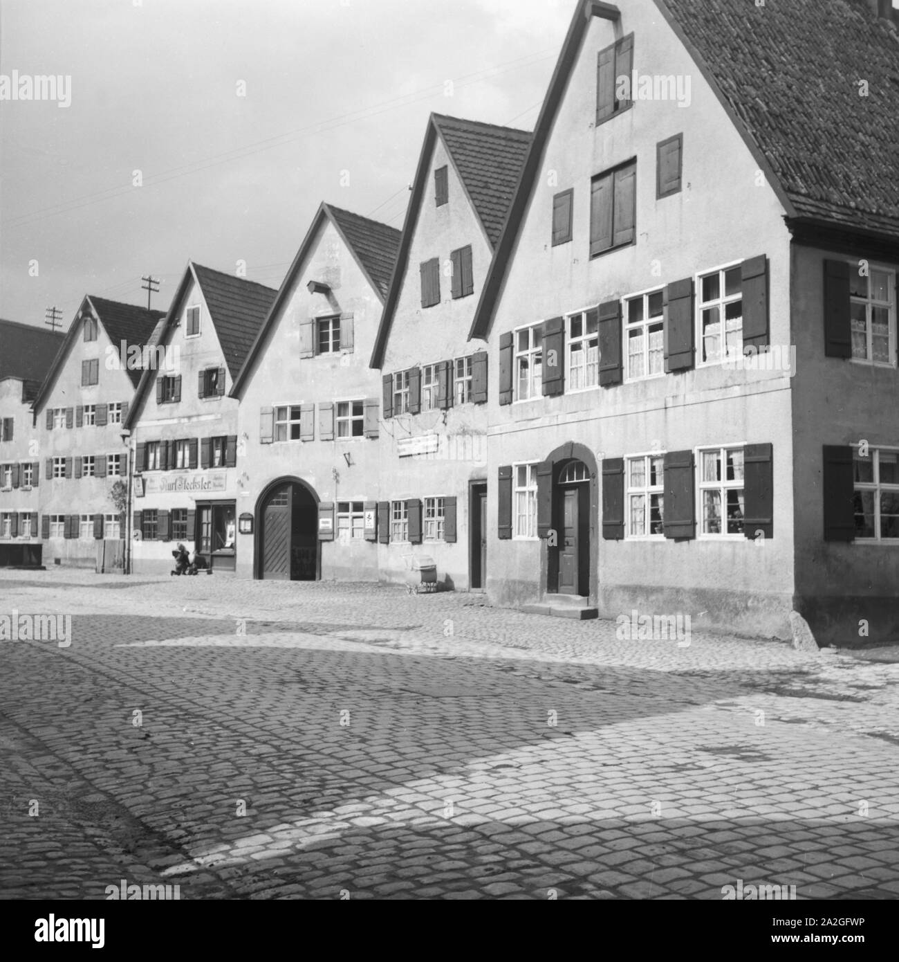 Dorfstraße mit Gebäuden in einer Kleinstadt, Deutschand 1930er Jahre. Rural street in a small town, Germany 1930s. Stock Photo