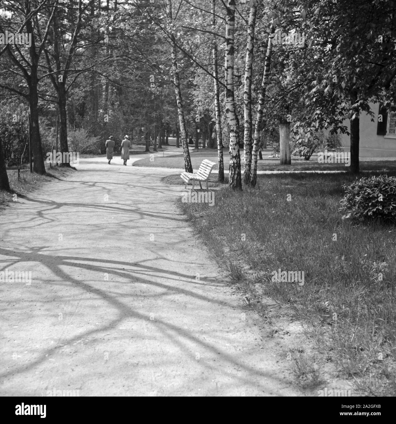 Parkbank in der Sonne, Deutschland 1930er Jahre. Bench at a public garden, Germany 1930s. Stock Photo