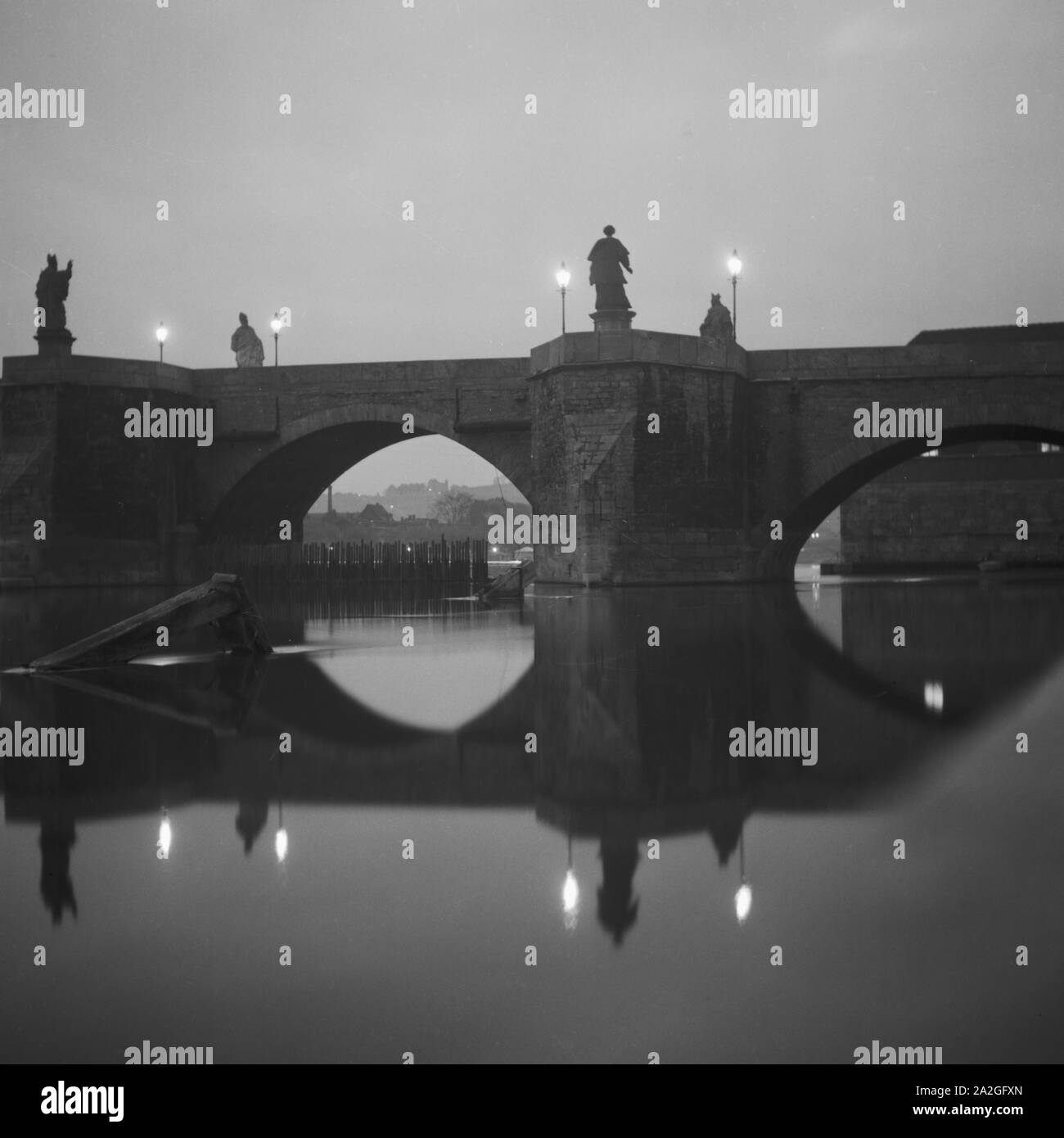 Brücke in der Abenddämmerung in Regensburg, Deutschland 1930er Jahre. Bridge at dawn in Regensburg, Germany 1930s. Stock Photo