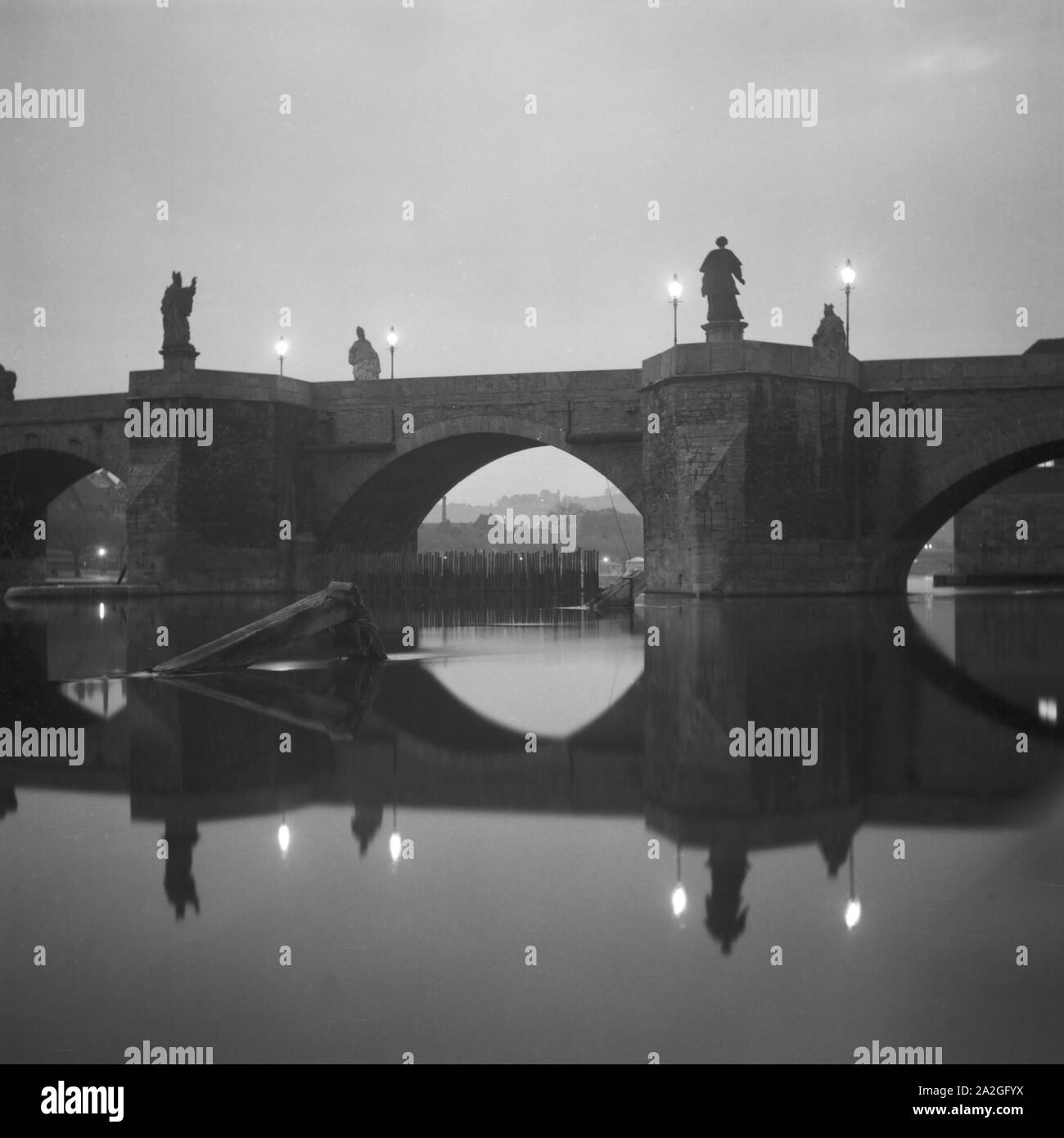 Brücke in der Abenddämmerung in Regensburg, Deutschland 1930er Jahre. Bridge at dawn in Regensburg, Germany 1930s. Stock Photo