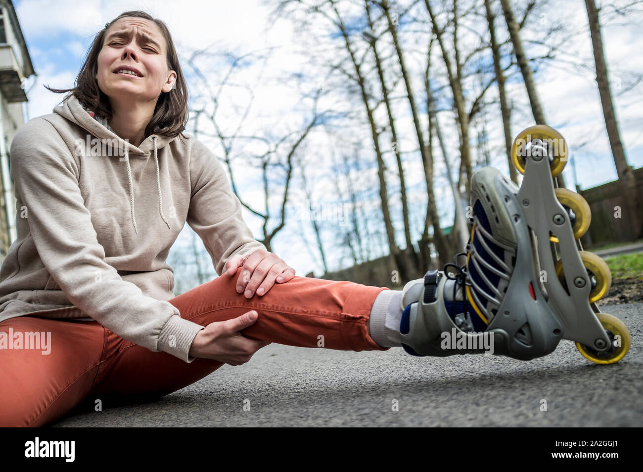 Cute woman fell riding on roller skates, and it really hurt his knee