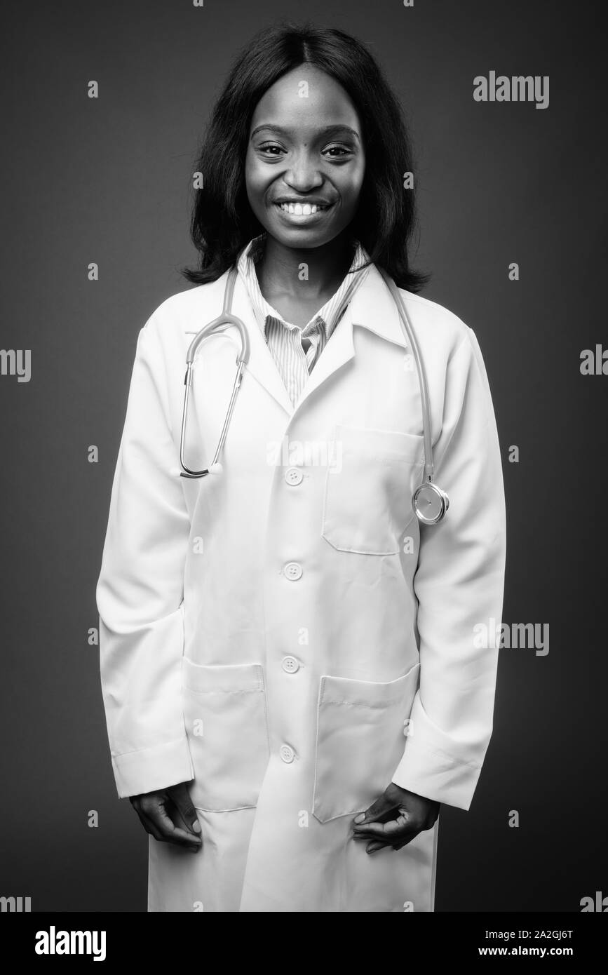 Young beautiful African Zulu woman doctor against brown background ...