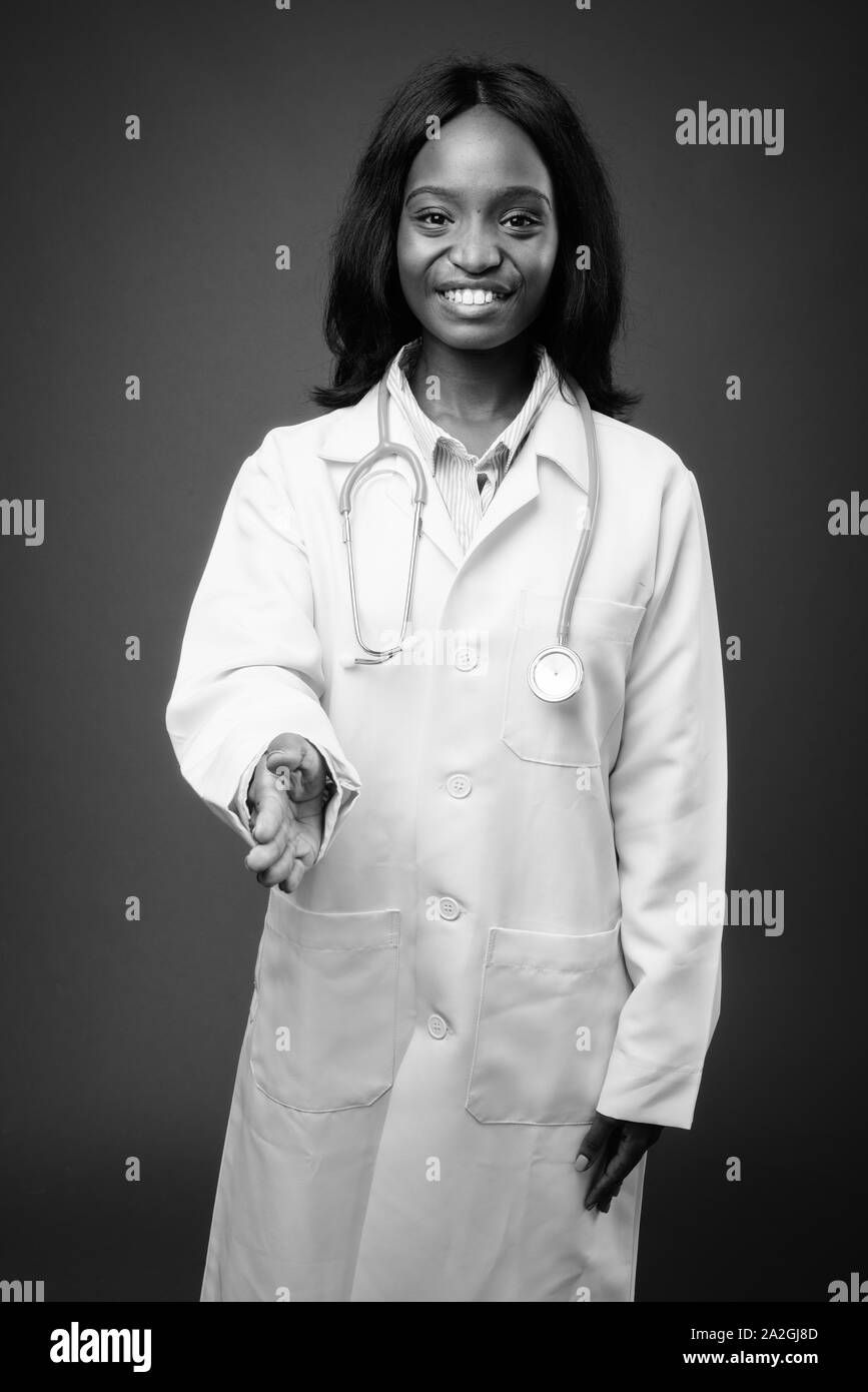 Young beautiful African Zulu woman doctor against brown background ...