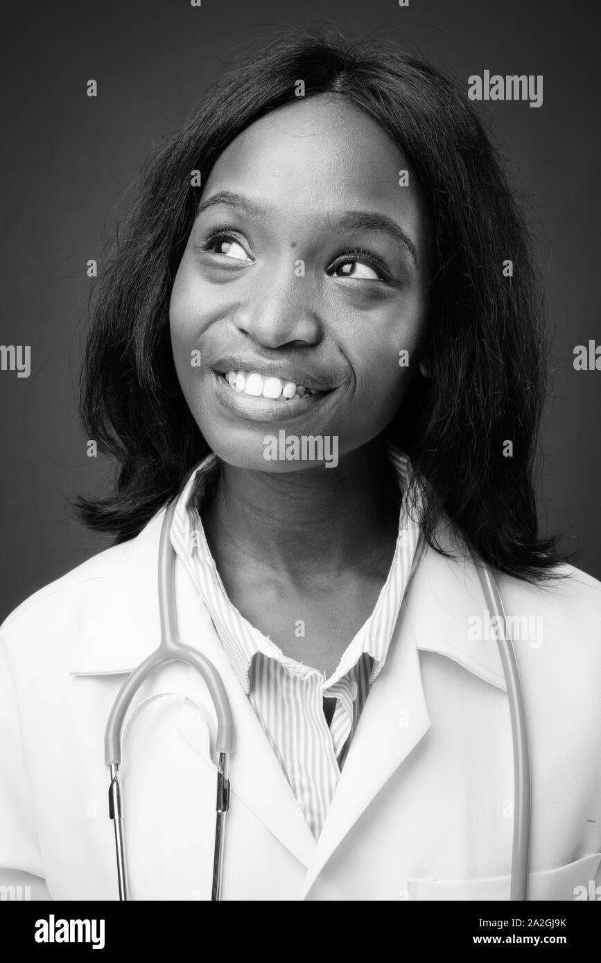 Young beautiful African Zulu woman doctor against brown background ...