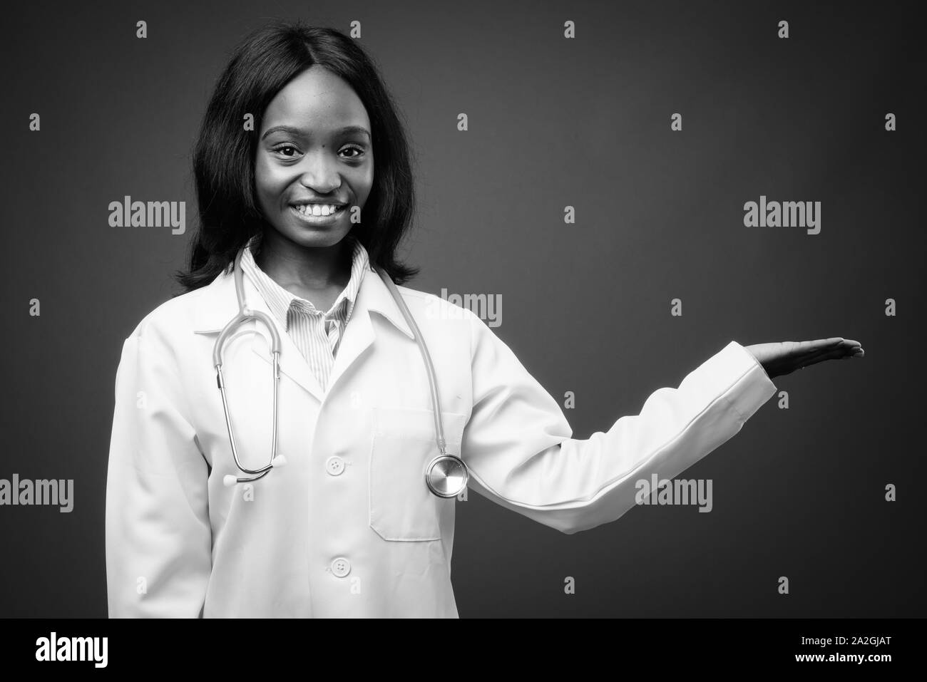 Young beautiful African Zulu woman doctor against brown background ...