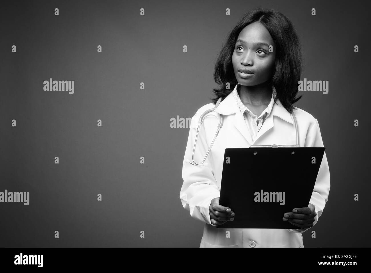 Young beautiful African Zulu woman doctor against brown background ...