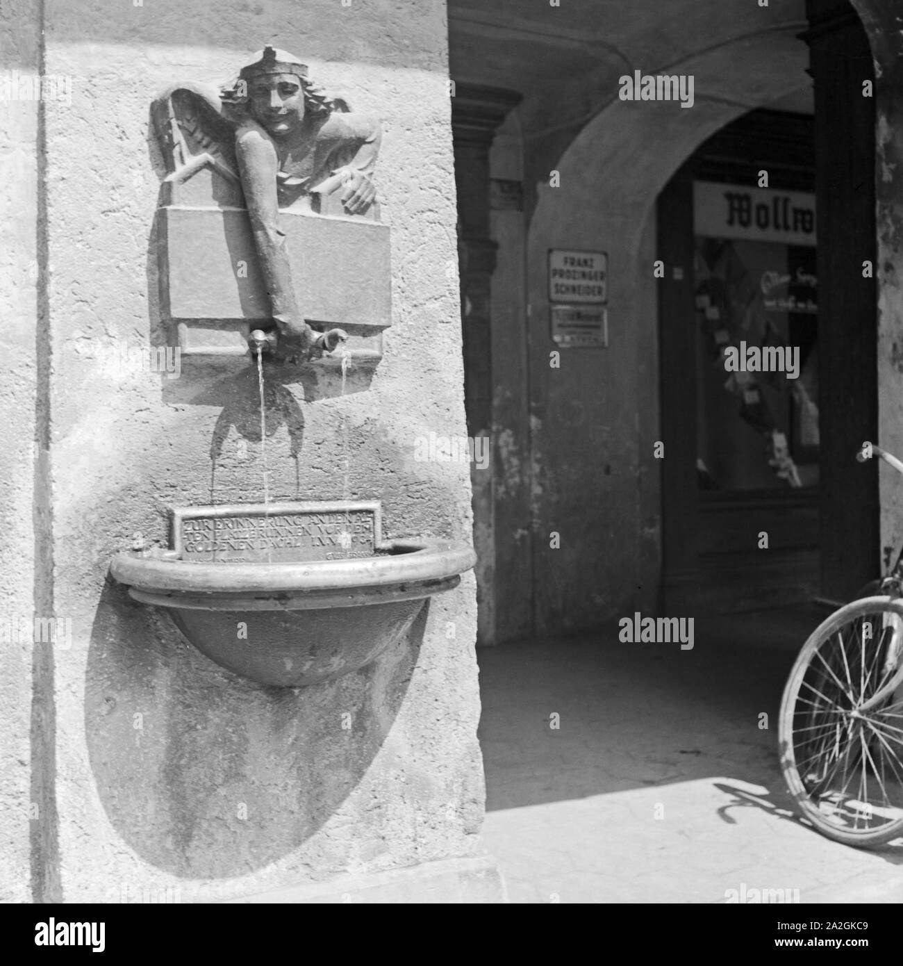 Kleiner Trinkwasserbrunnen vor dem Haus mit dem Goldenen Dachl in Innsbruck in Österreich, Deutschland 1930er Jahre. Small water fountain at the building with the Goldenes Dachl roof at Innsbruck in Austria, Germany 1930s. Stock Photo