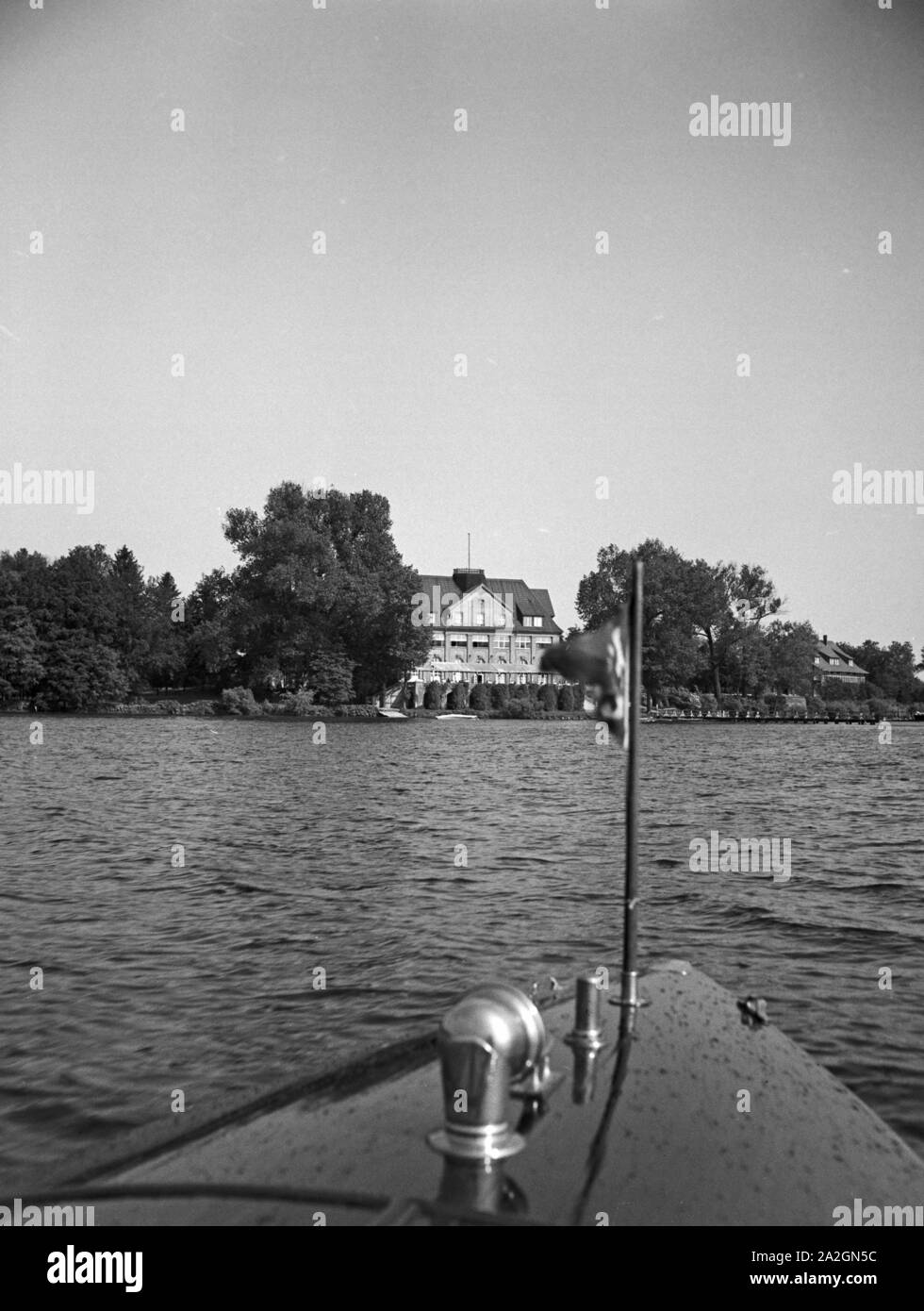 Ein Mann unterwegs in seinem Motorboot auf einem See, Deutschland 1930er Jahre. A man on a lake in his motor boar, Germany 1930s. Stock Photo