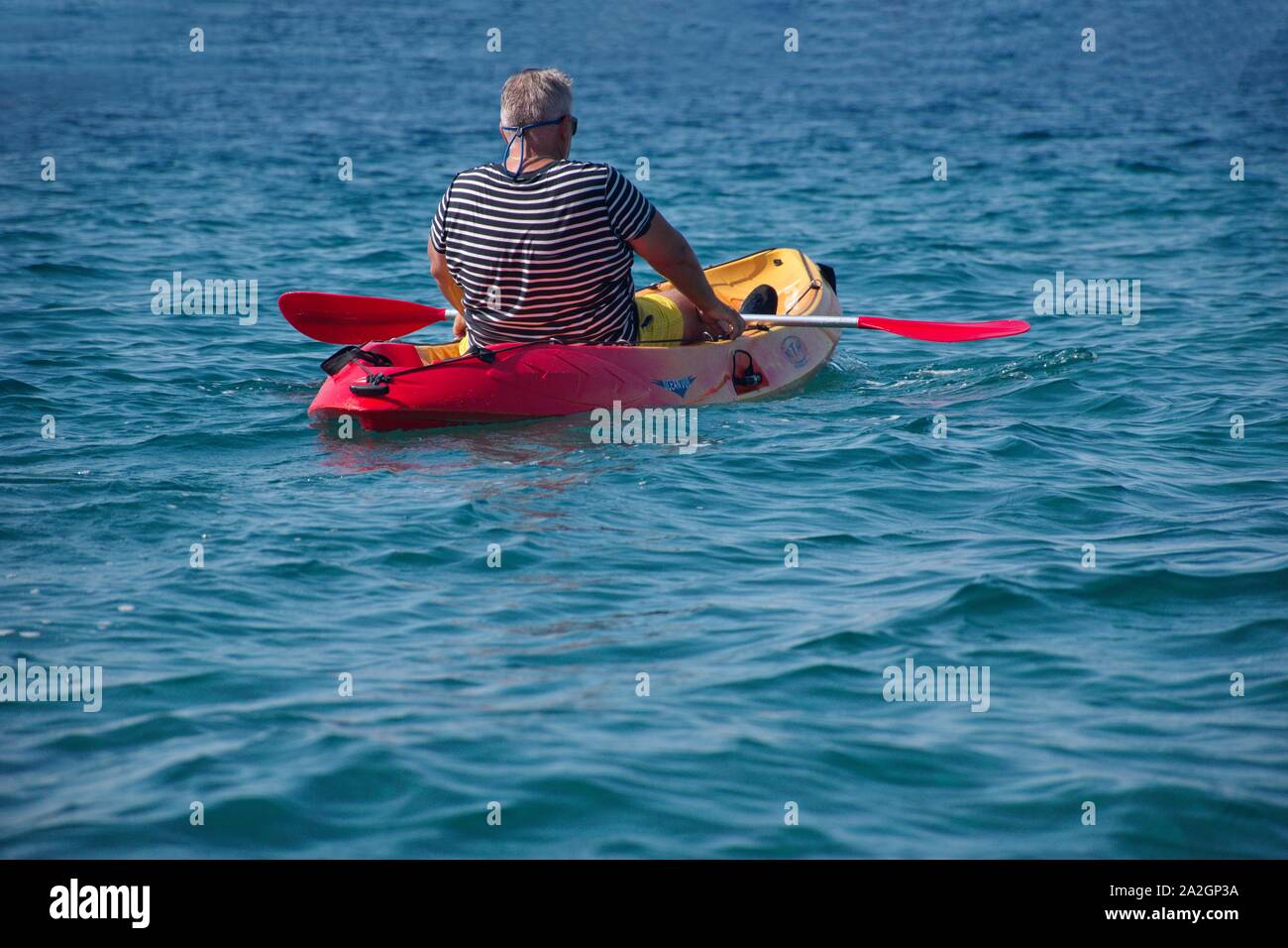 Rear view of senior man paddling in kayak on Adriatic sea Stock Photo