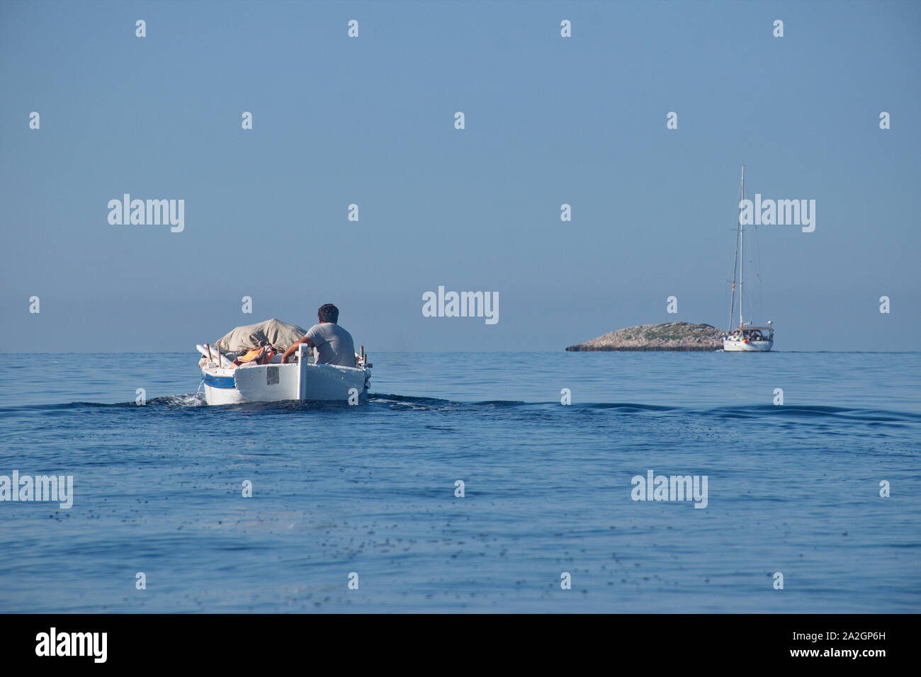 Rear view of wooden traditional boat with fisherman sailing on Adriatic ...
