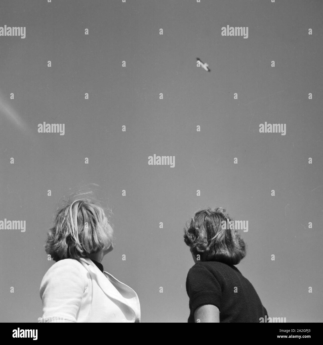 Zwei Frauen beobachten einen Raubvogel beim Kreisen in der Luft, Deutschland 1930er Jahre. Two women watching a raptor in the air, Germany 1930s. Stock Photo