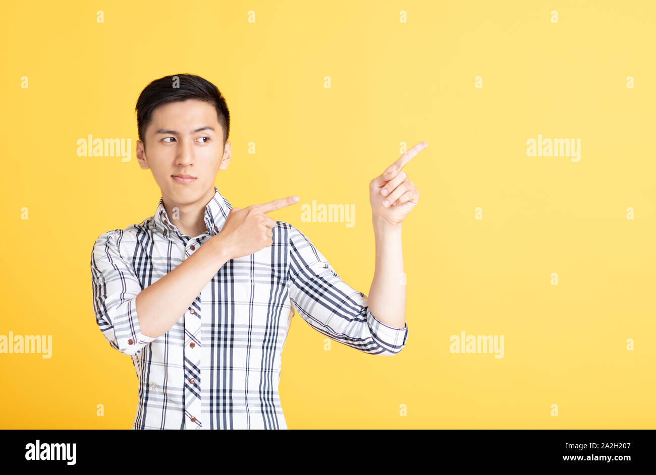 handsome young man pointing and showing Stock Photo