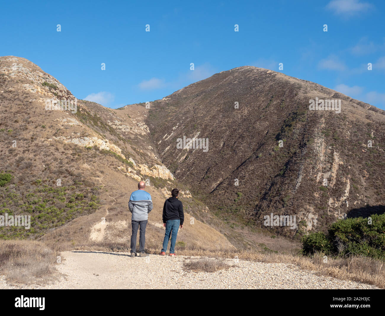 Father and son hiking in Montana de Oro State Park with Valenica Peak in the distance, Los Osos, California, USA Stock Photo